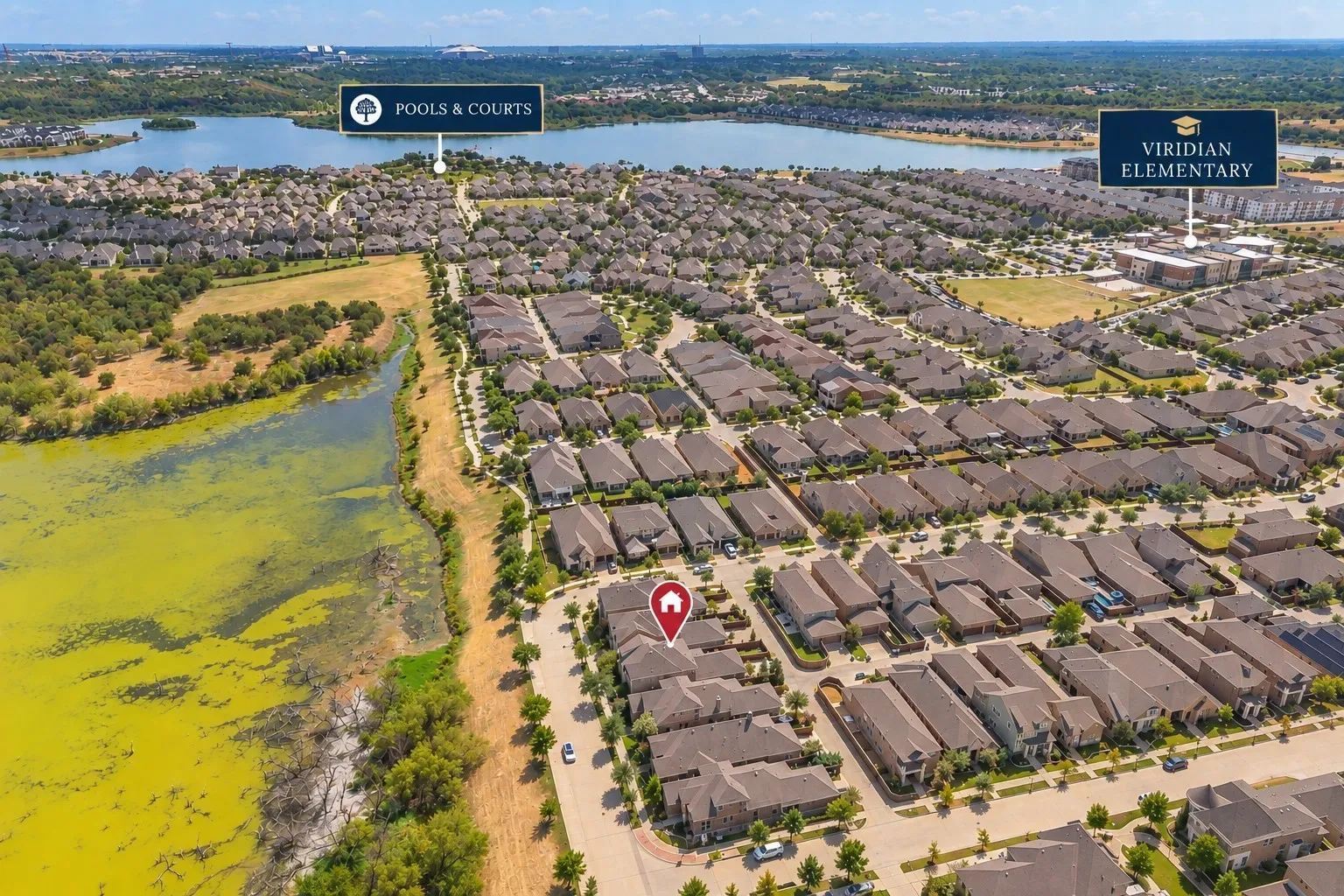 Aerial overview of a residential neighborhood featuring numerous single-family homes, a prominent lake, and community amenities
