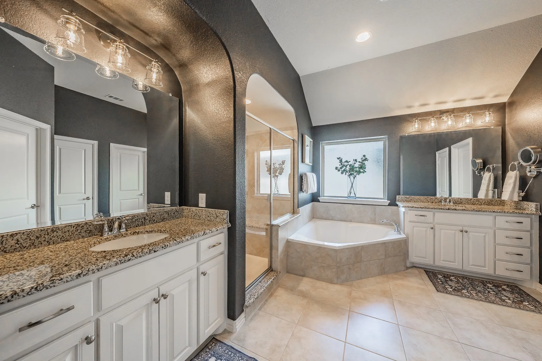 Dual vanity with granite countertops and white cabinetry