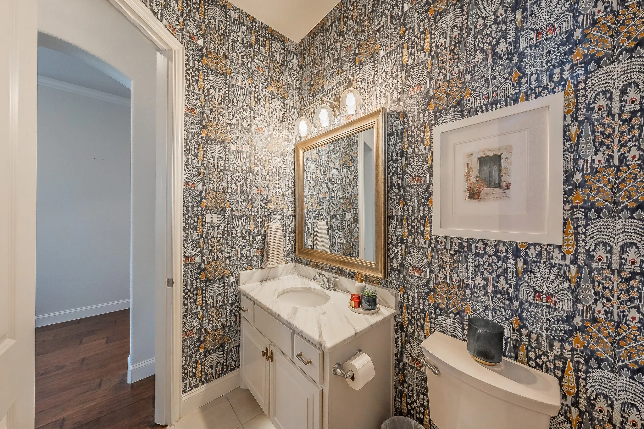 Vanity with marble-finish countertop, single basin sink, and gold-tone faucet