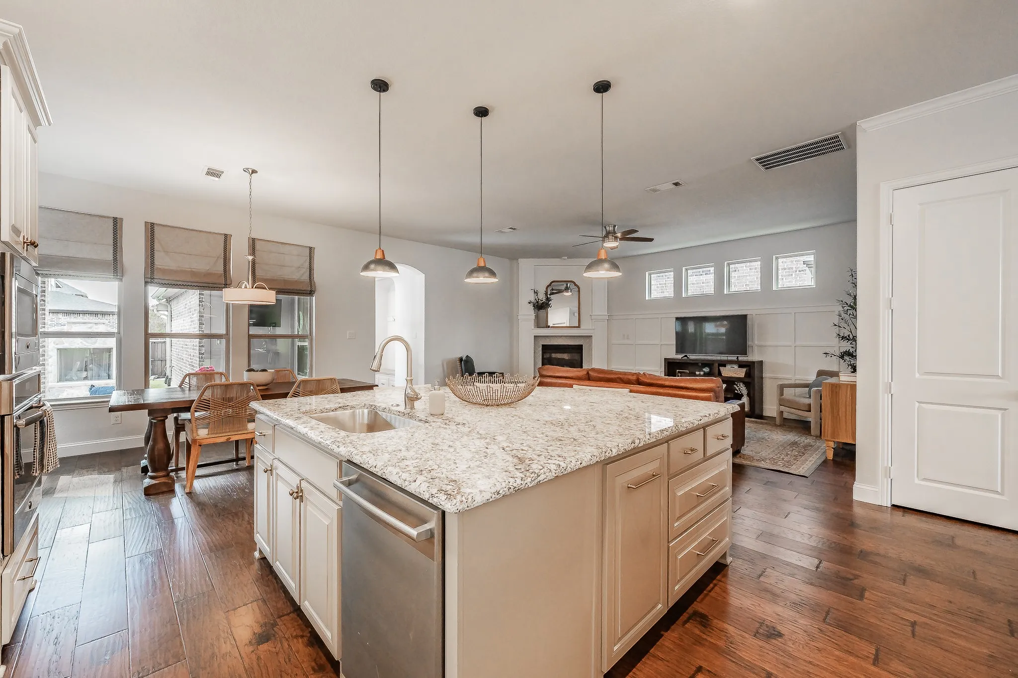 Kitchen island with granite countertop, integrated sink, and stainless-steel appliances