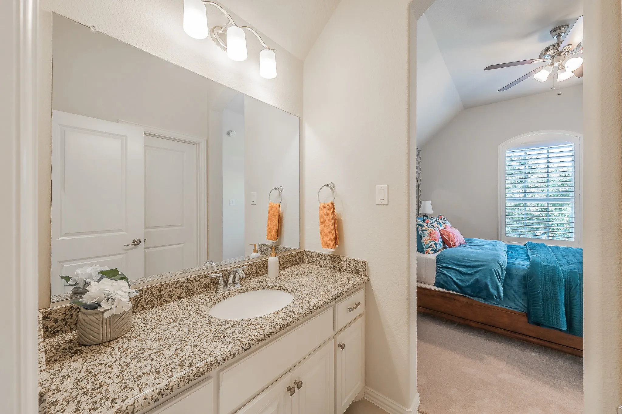 Single vanity with an undermount sink, granite-style countertop, and white cabinetry