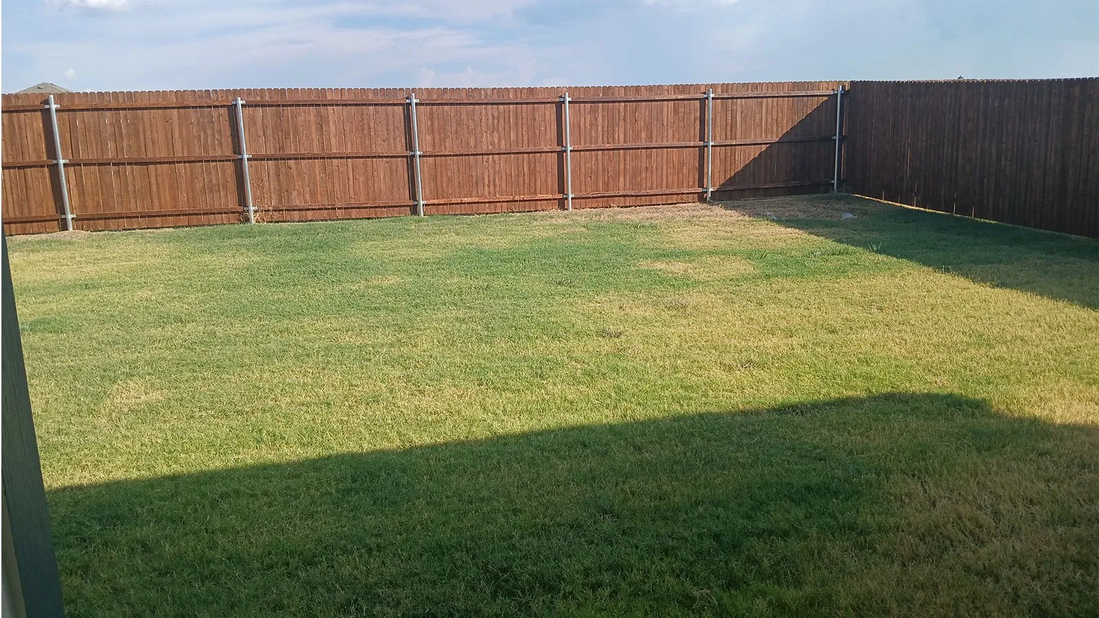 Expansive backyard with a manicured lawn and a privacy fence