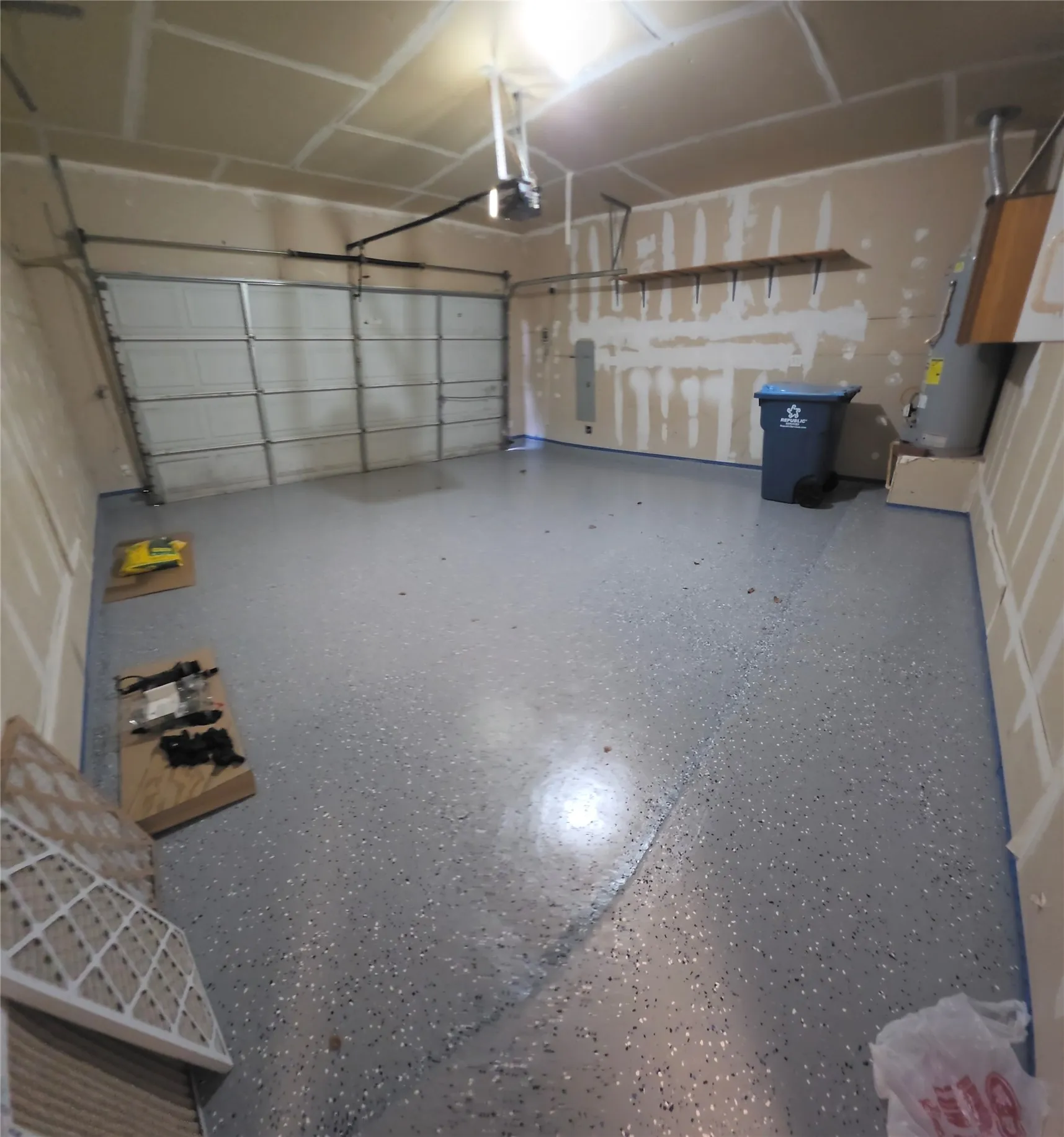 Garage with coated concrete flooring and an automatic garage door opener
