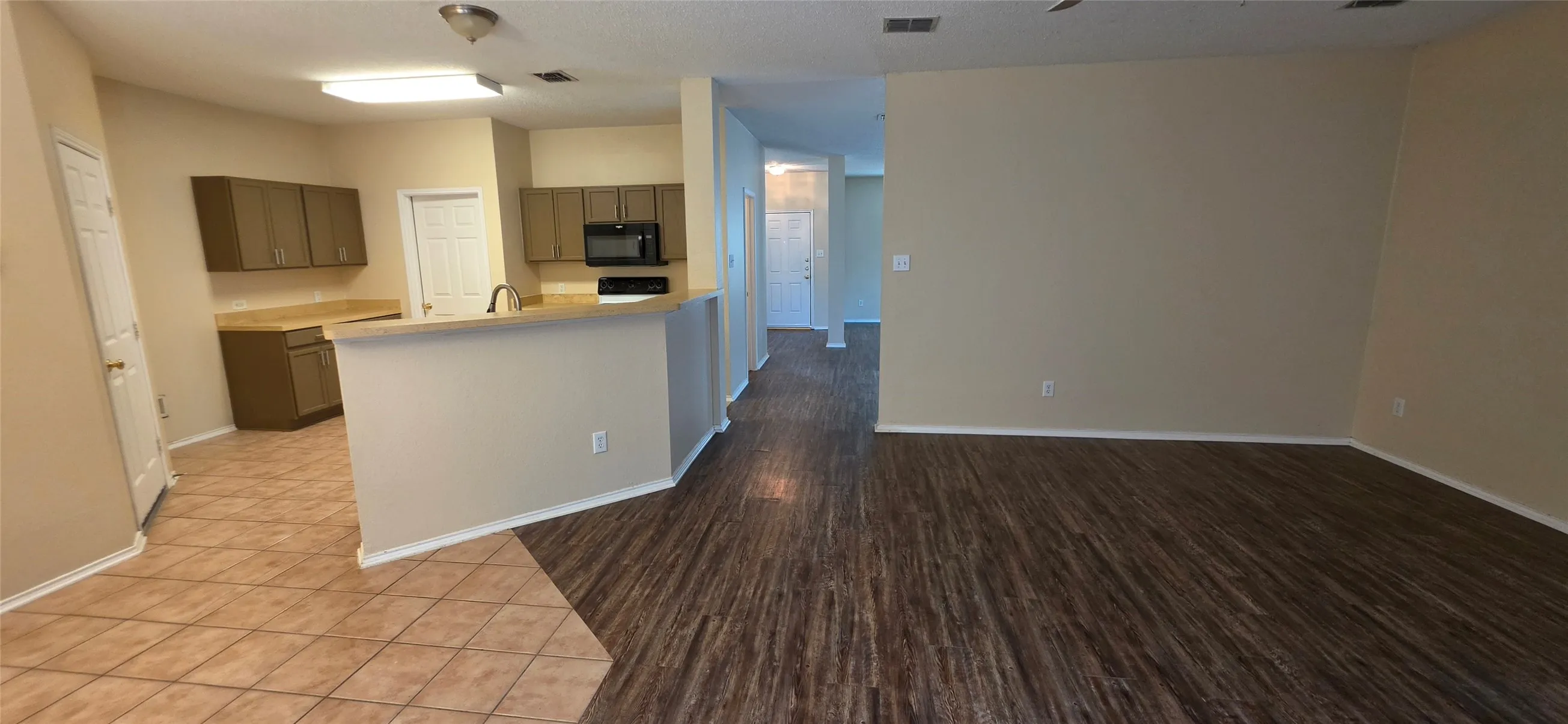 Open-concept living area featuring wood-finish flooring and neutral wall tones