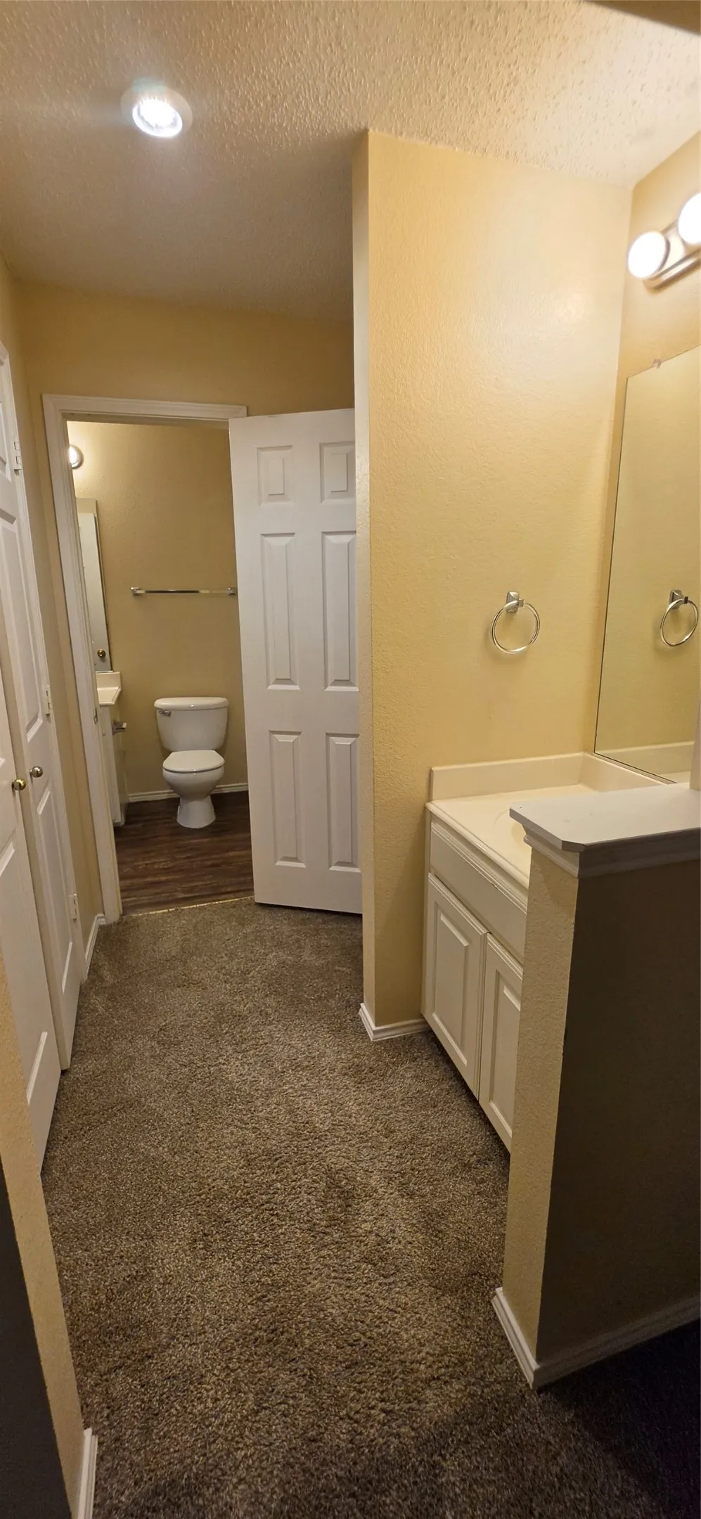Integrated vanity with white cabinetry, light-toned countertop, and mirror