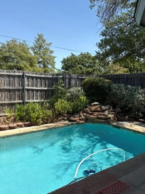 Backyard oasis with inground pool with waterfall and attached spa