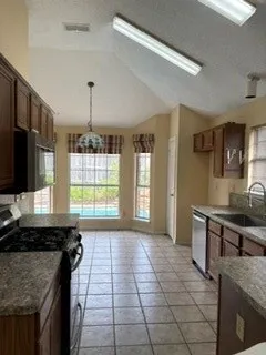 Galley kitchen with stainless appliances and tile flooring