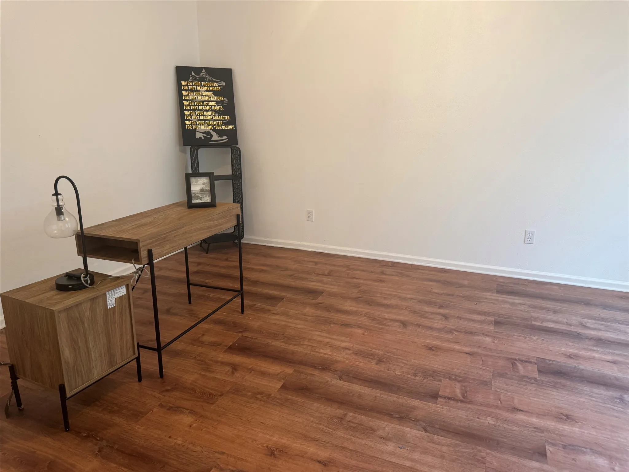 Wood-finish flooring with white baseboards and light-toned walls. Can also be used as a flex space.