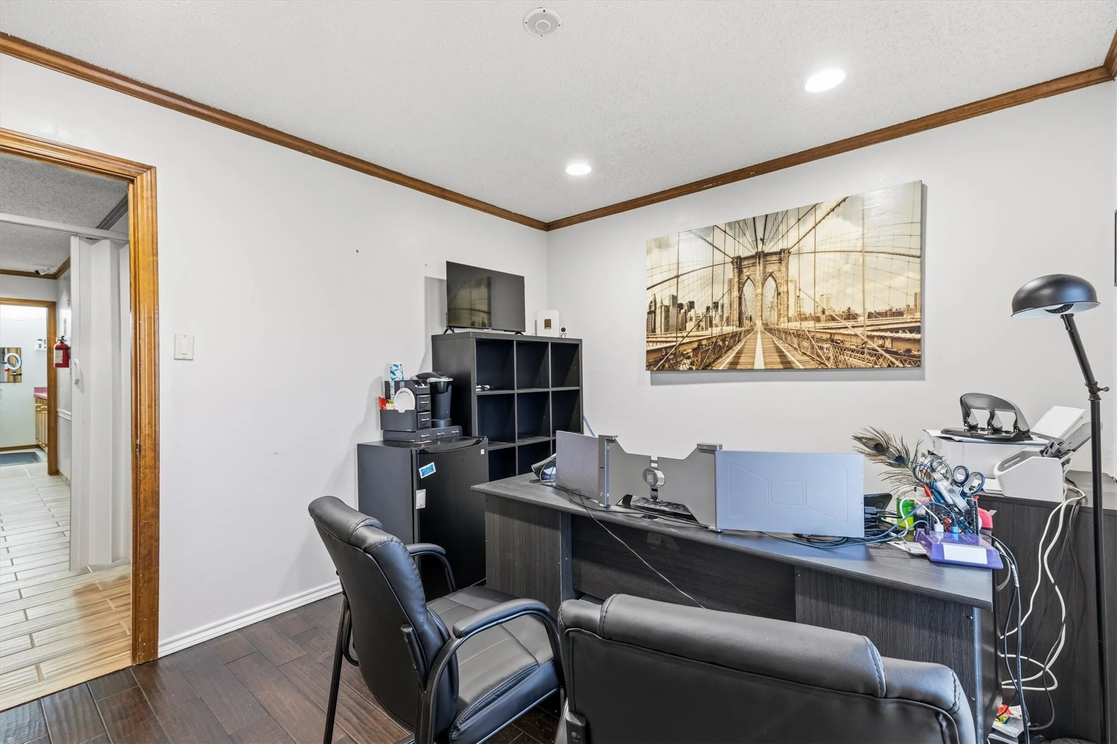 Recessed lighting, wood-finish flooring, wood trim, white walls, and a built-in shelving unit
