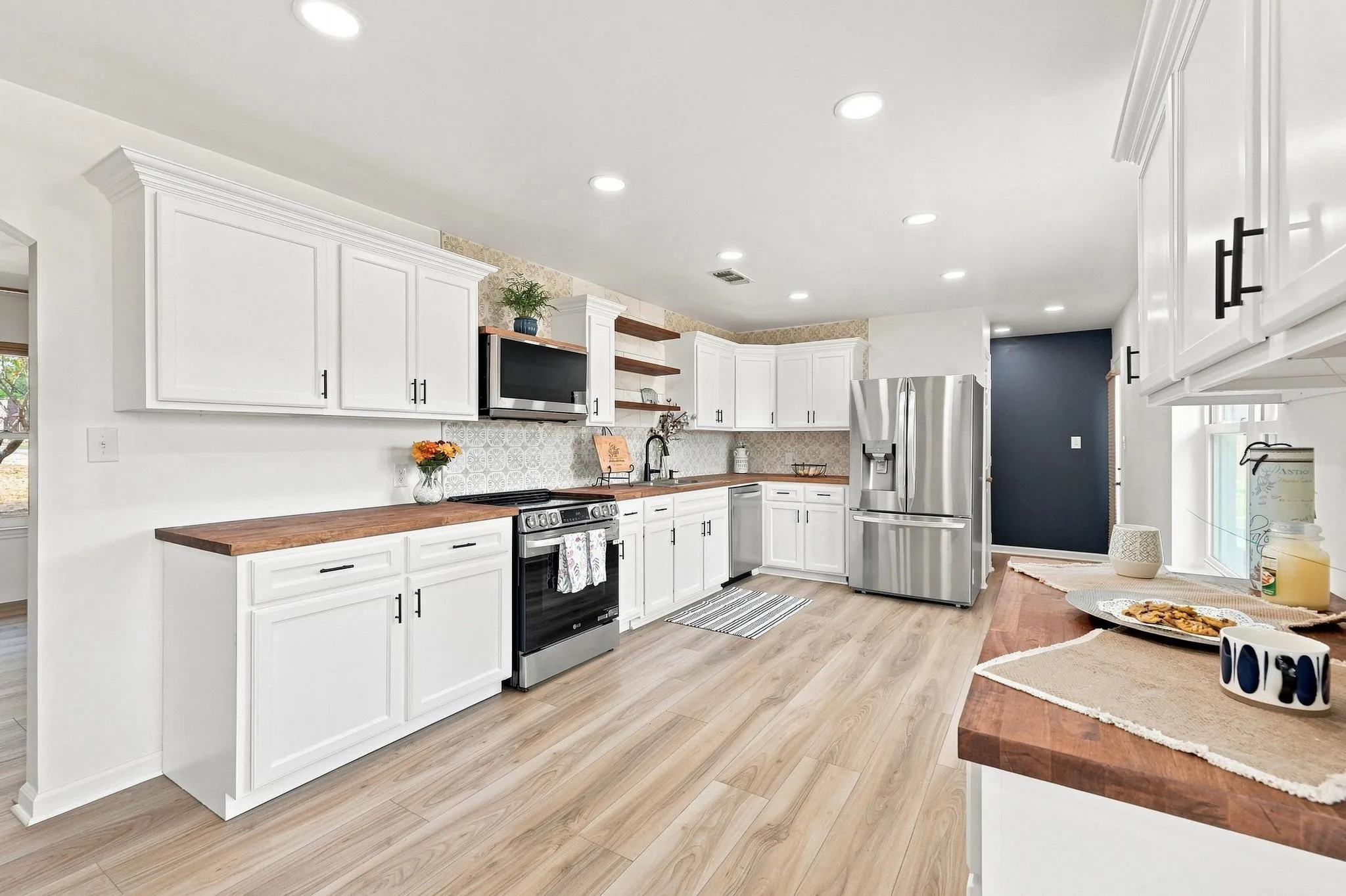 Kitchen featuring new white cabinetry, wood-finish countertops, stainless steel appliances, a decorative tiled backsplash, and recessed lighting