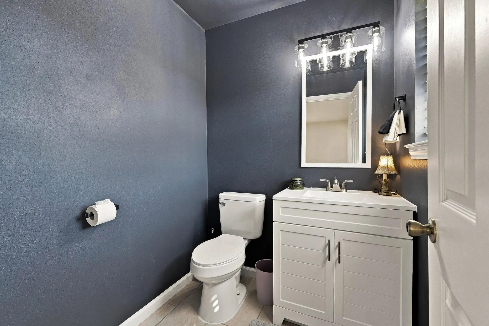White vanity with integrated sink, chrome faucet, and panel-front cabinetry