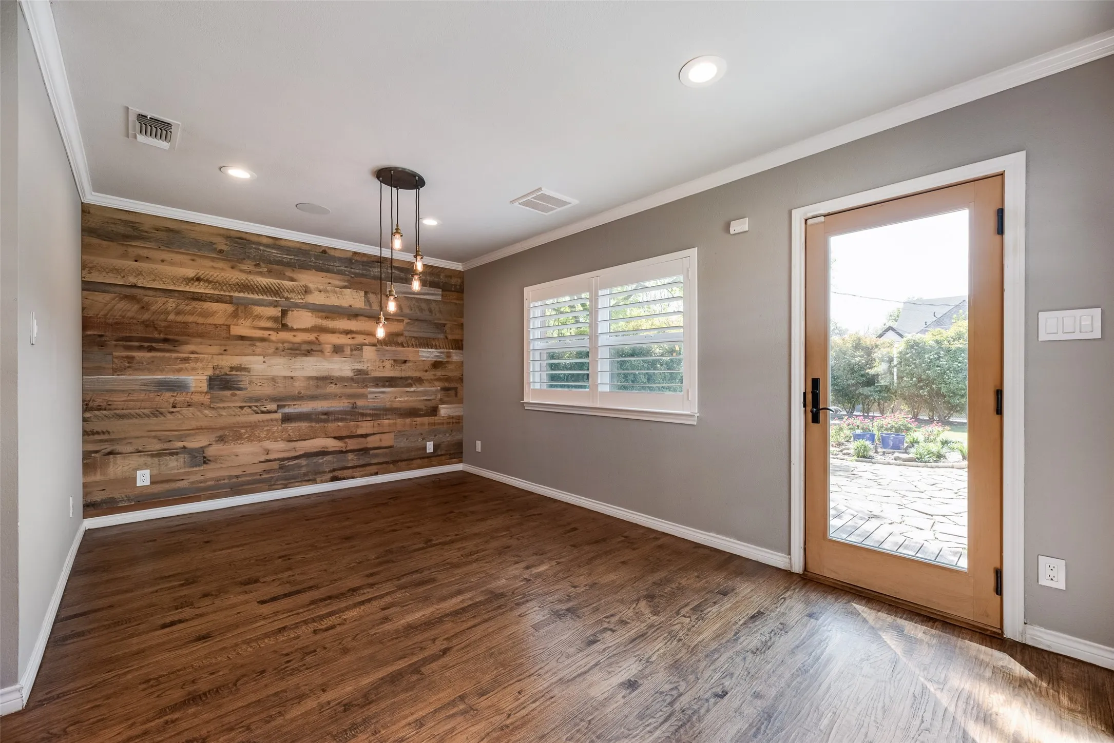 Spare room featuring wooden walls, dark wood finished floors, crown molding, and recessed lighting