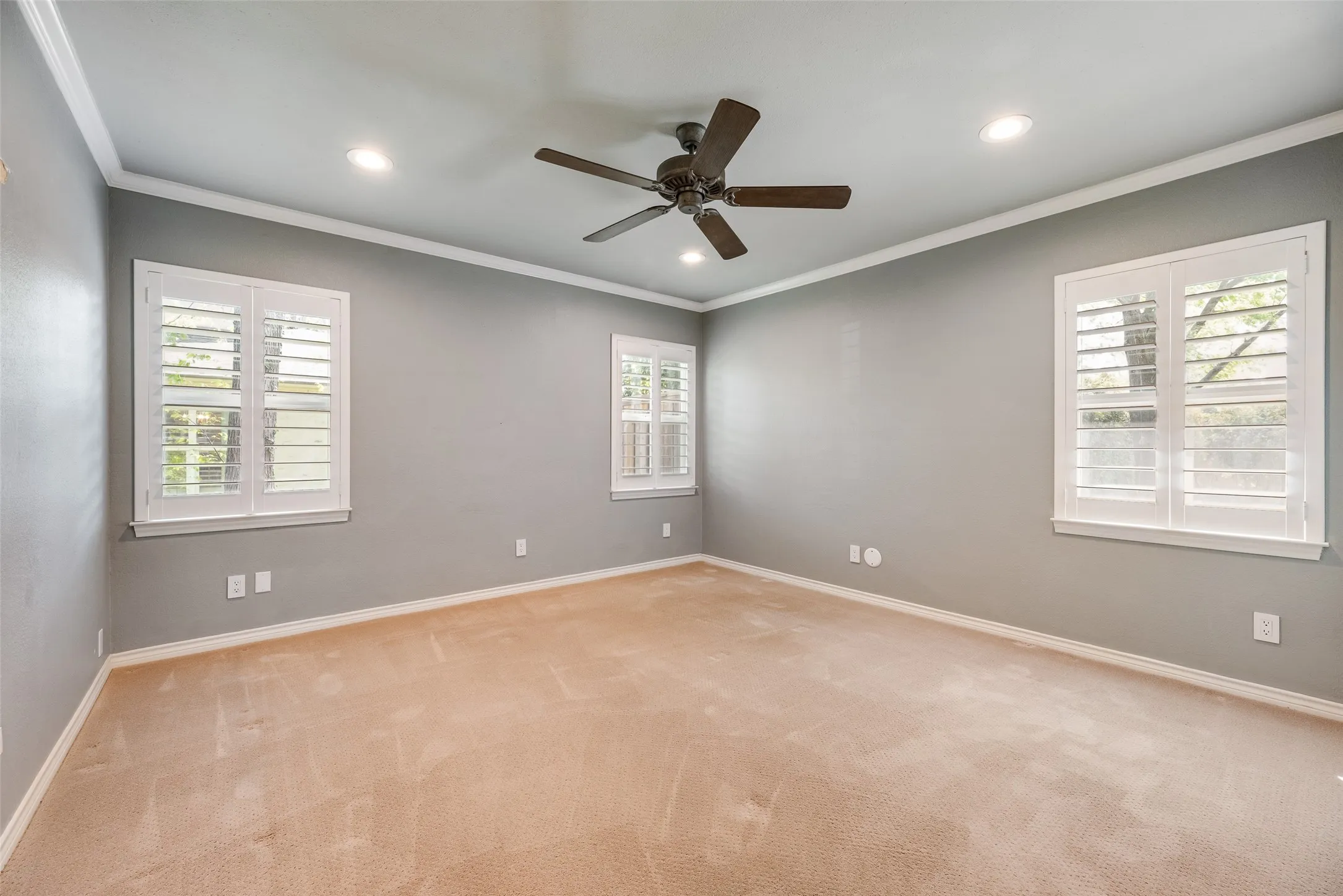 Spare room featuring light colored carpet, ceiling fan, crown molding, and recessed lighting