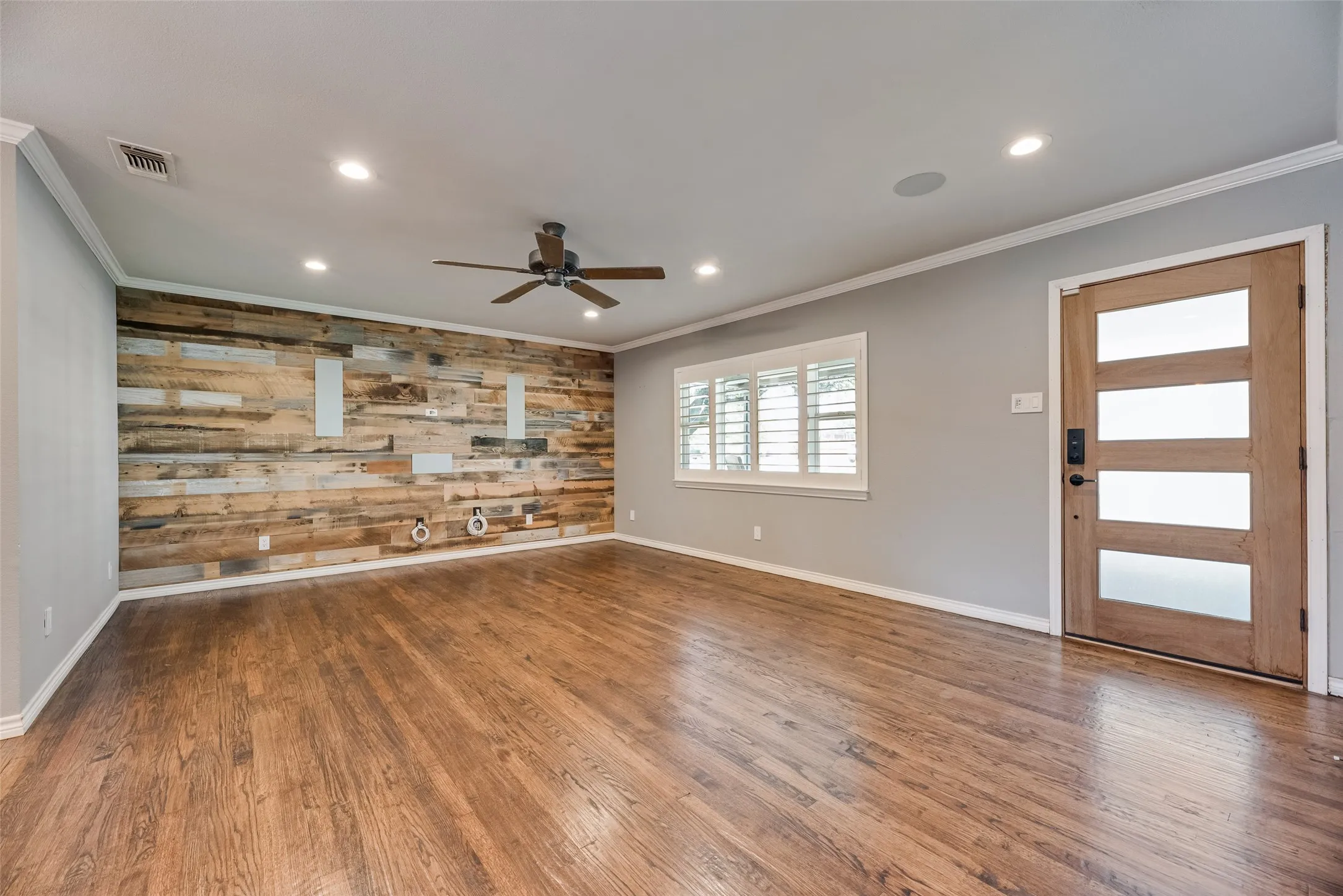 Spare room featuring wooden walls, dark wood-style floors, a ceiling fan, ornamental molding, and recessed lighting