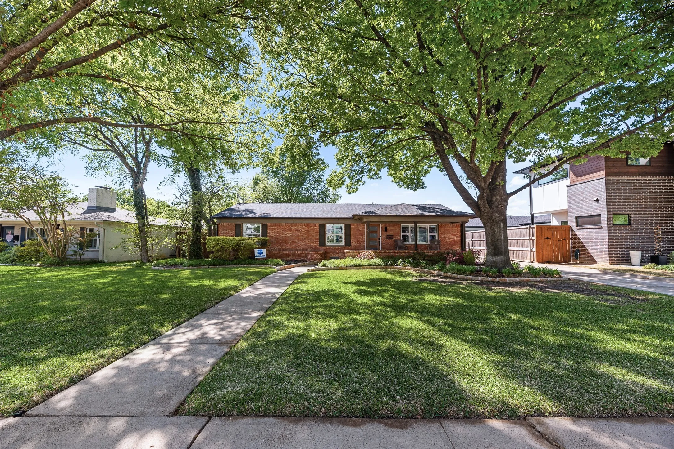 Ranch-style house featuring brick siding and a gate