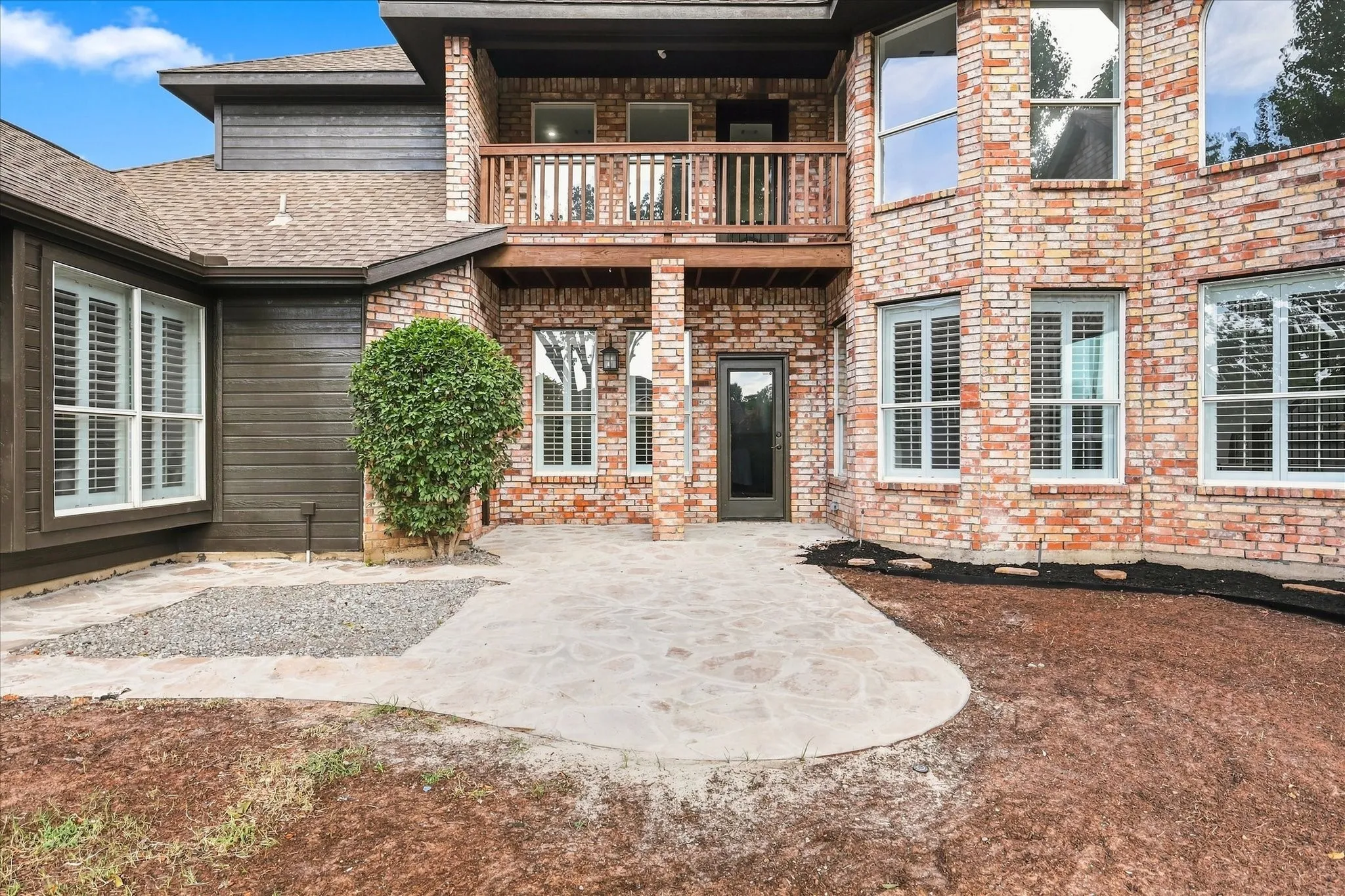The home hass a balcony , a huge back yard with mature trees & lots of windows to bring in the light.