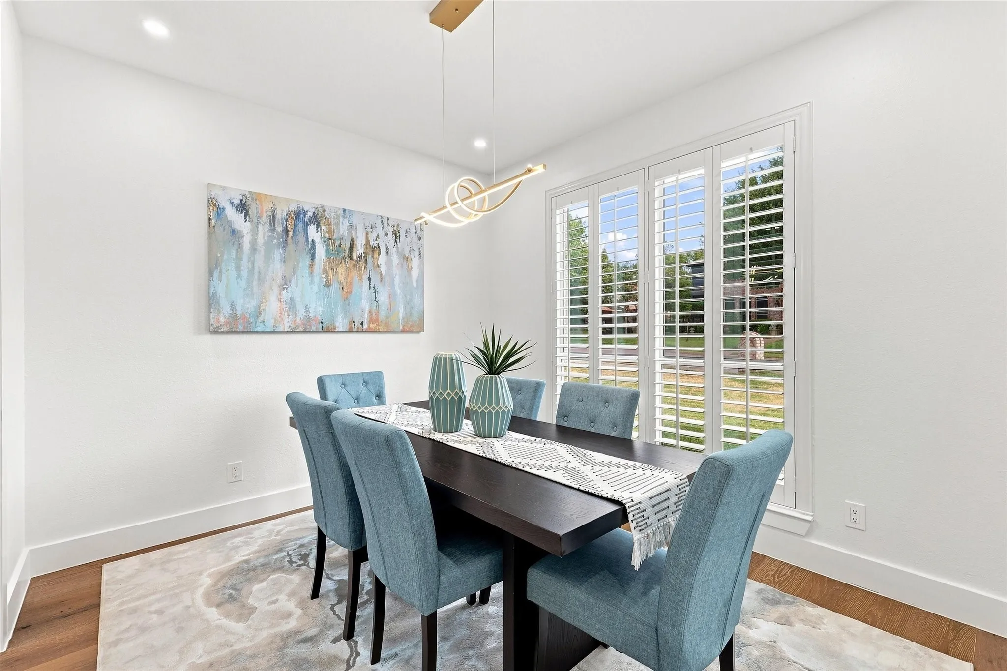 Spacious formal dining with elegant plantation shutters.