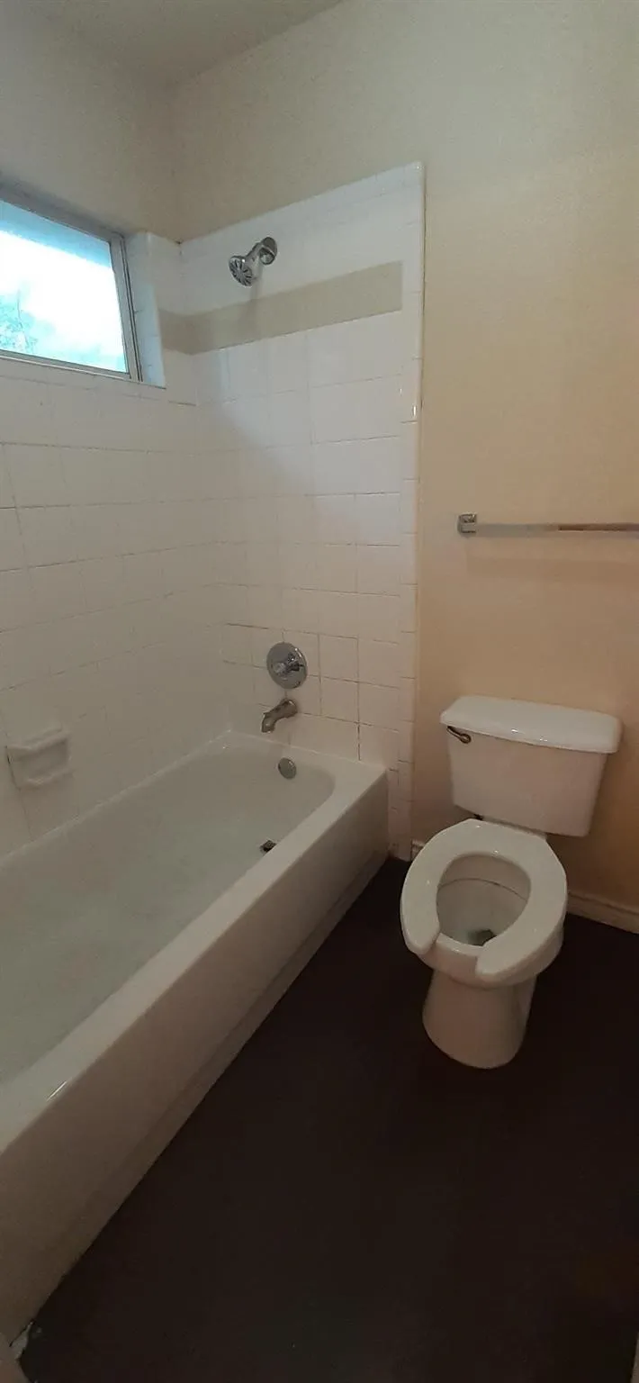 White tile bath enclosure with integrated tub and shower fixture