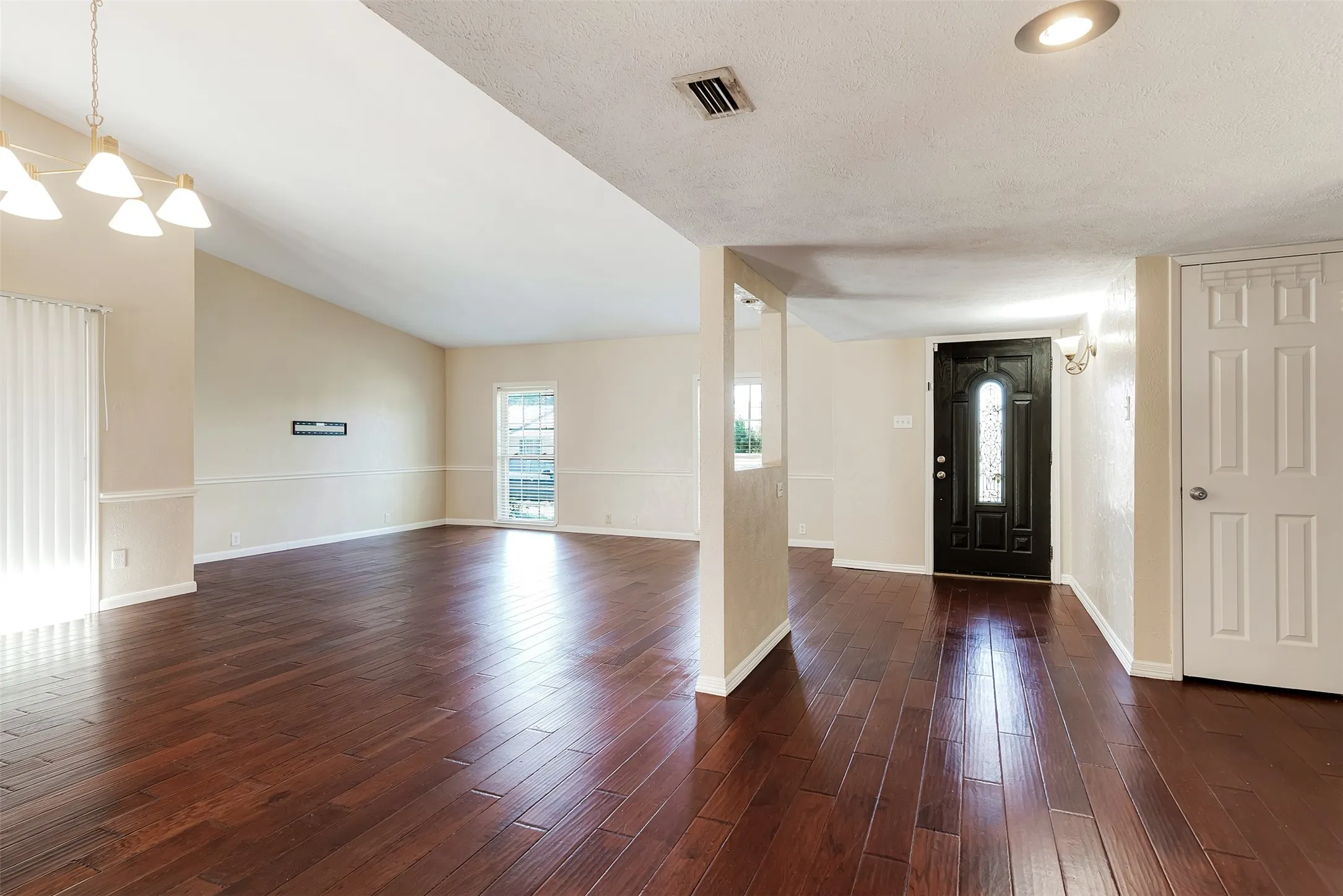 Wood-finish flooring throughout, vaulted ceiling, and recessed lighting