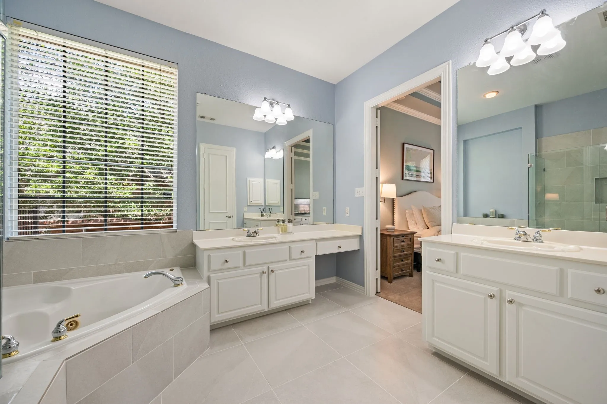 Separate vanities provide plenty of personal space, storage & counter room in the bright owner’s bath.