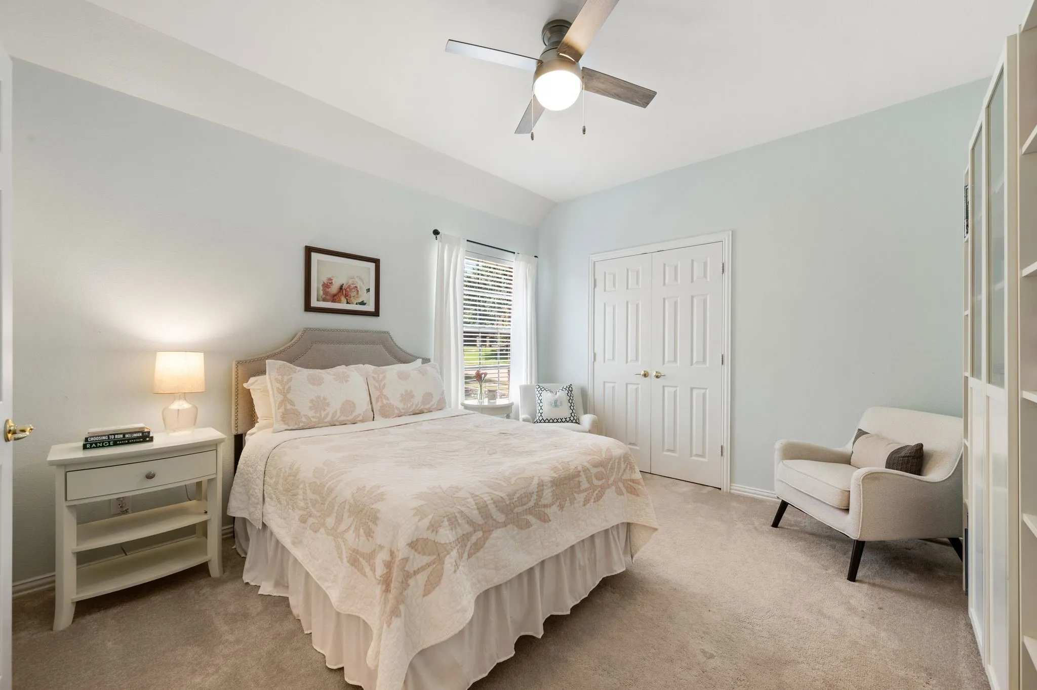 Spacious secondary bedroom features a vaulted ceiling, soft neutral finishes & generous closet space.