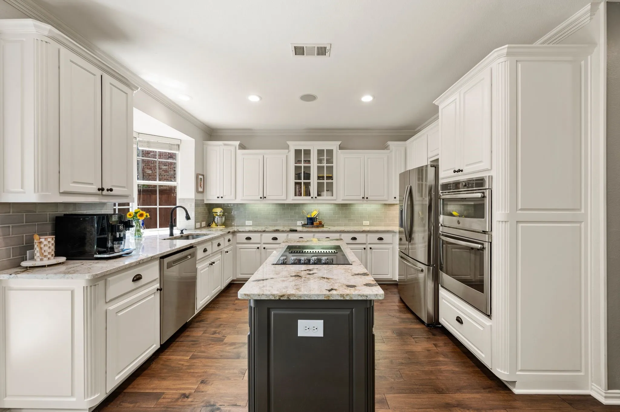 Spacious kitchen features abundant cabinetry, granite countertops, a center island & stainless steel appliances.