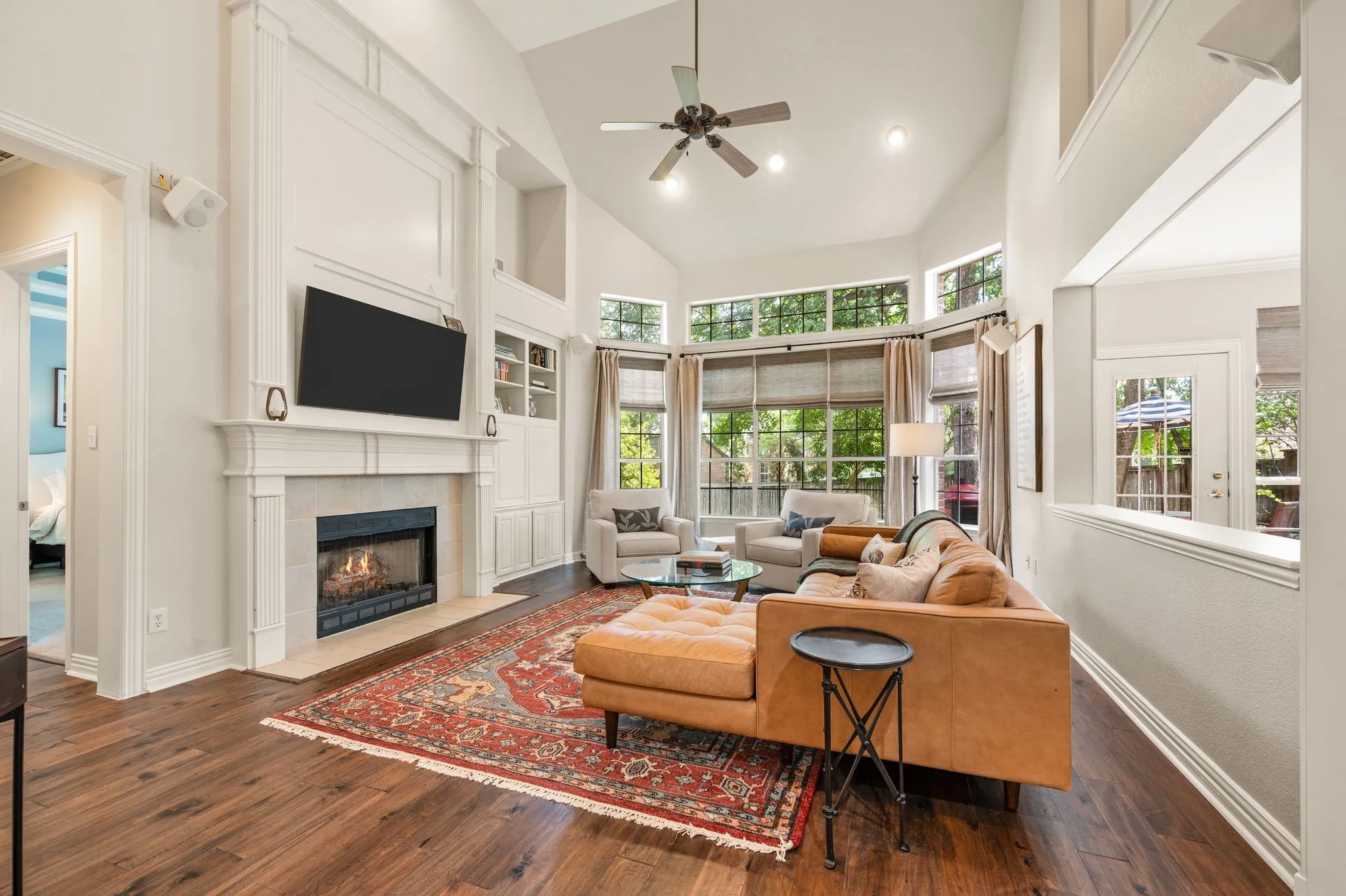 The spacious family room offers vaulted ceilings, a cozy fireplace, built-ins & walls of windows framing backyard​​‌​​​​‌​​‌‌​‌‌​​​‌‌​‌​‌​‌​​​‌​​ views.