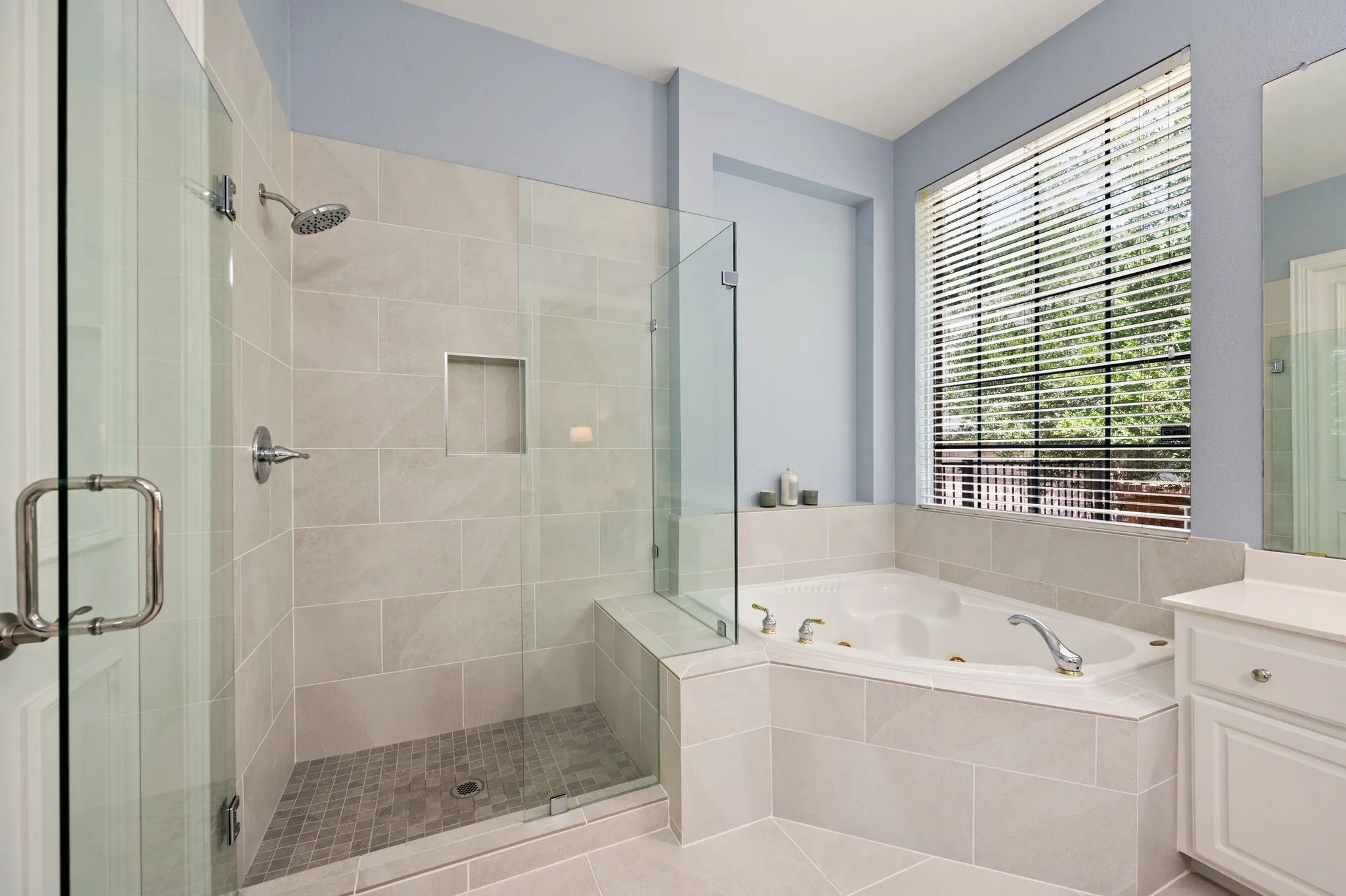 Relax and recharge with a spacious tiled shower, jetted soaking tub & peaceful views of the backyard greenery.