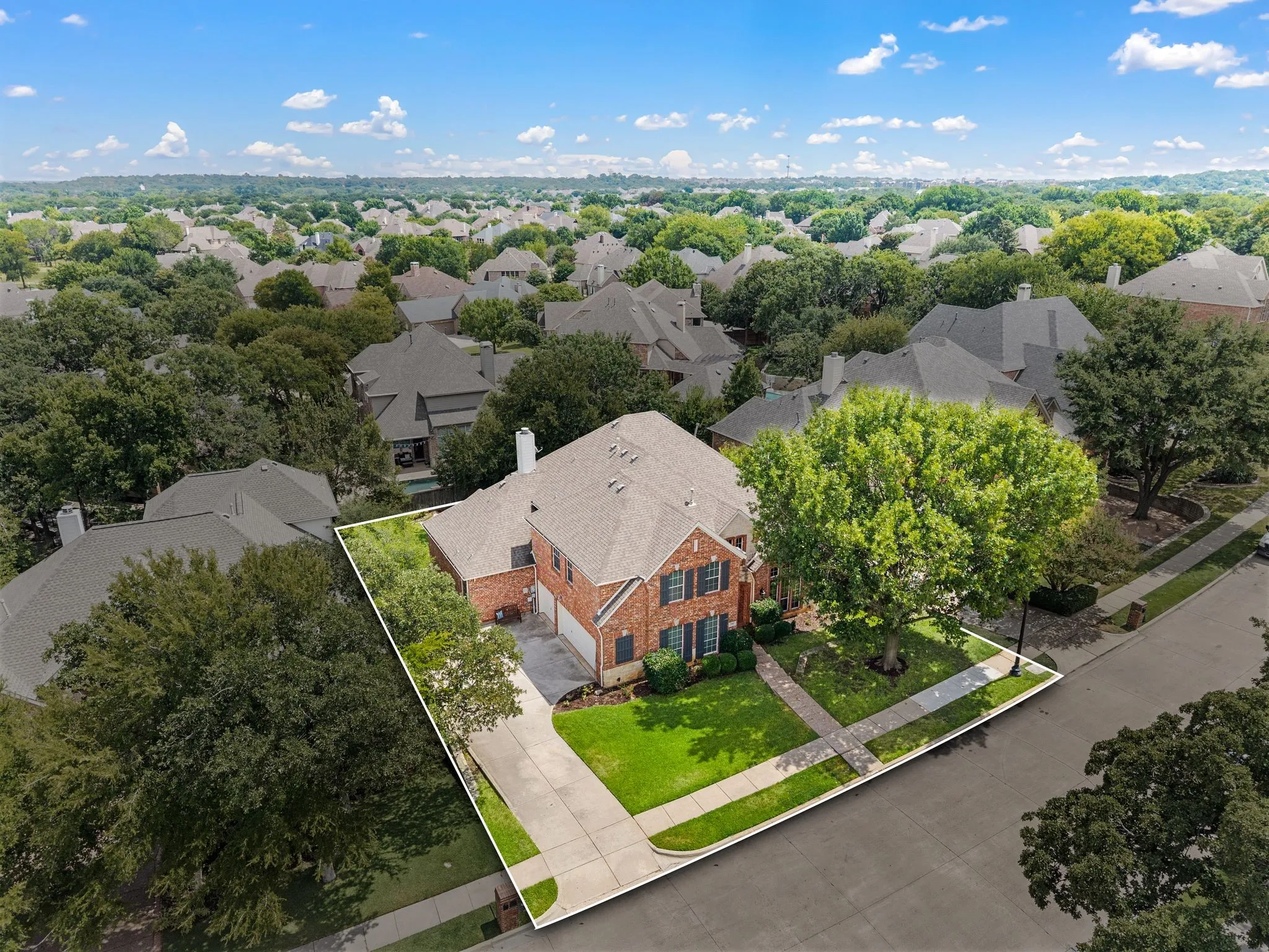 Aerial view highlights the home’s generous lot, spacious driveway & lovely setting within an established, tree-filled neighborhood.