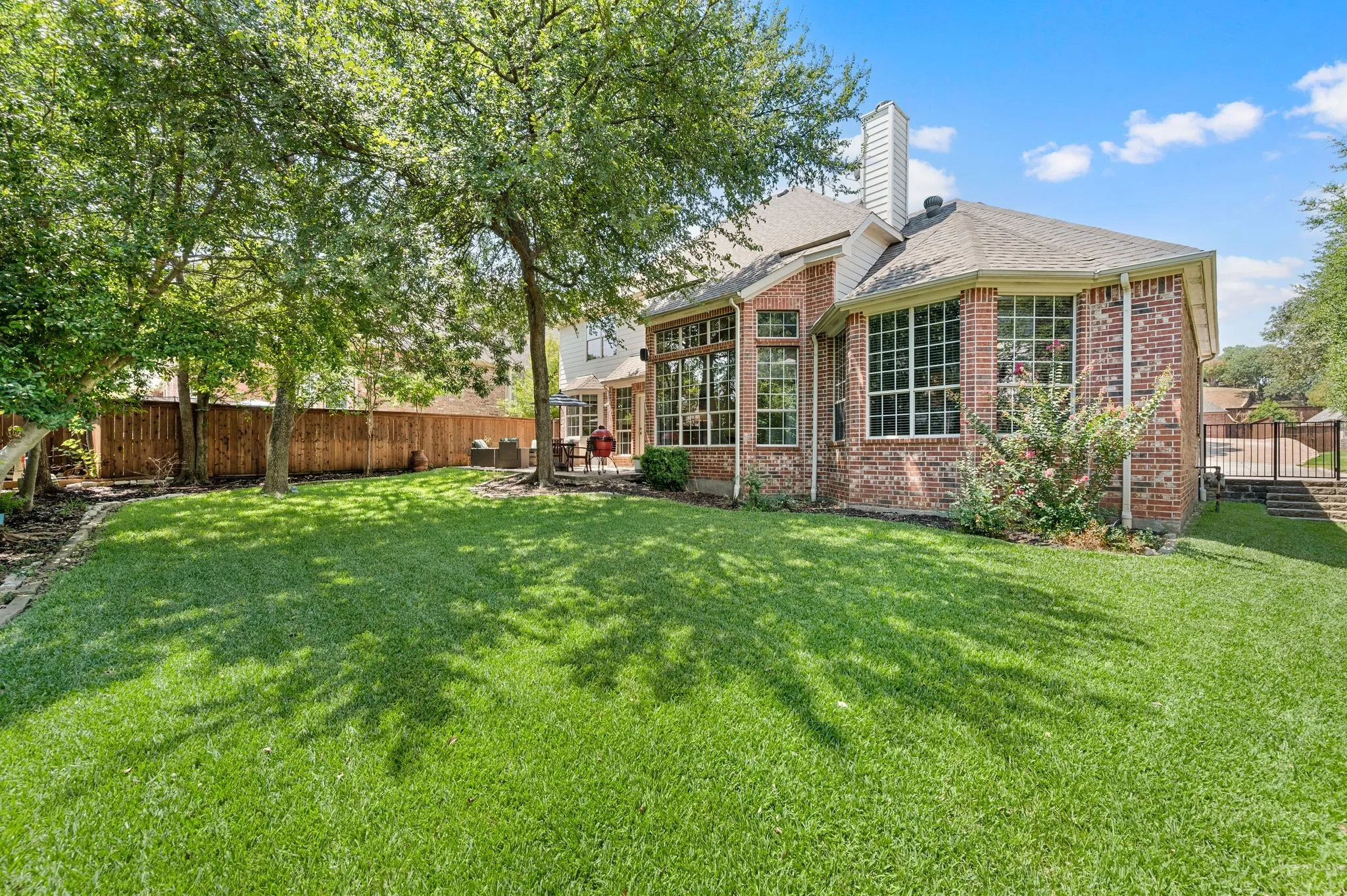 The large, beautifully maintained backyard offers mature shade trees, lush lawn & plenty of room for outdoor fun.