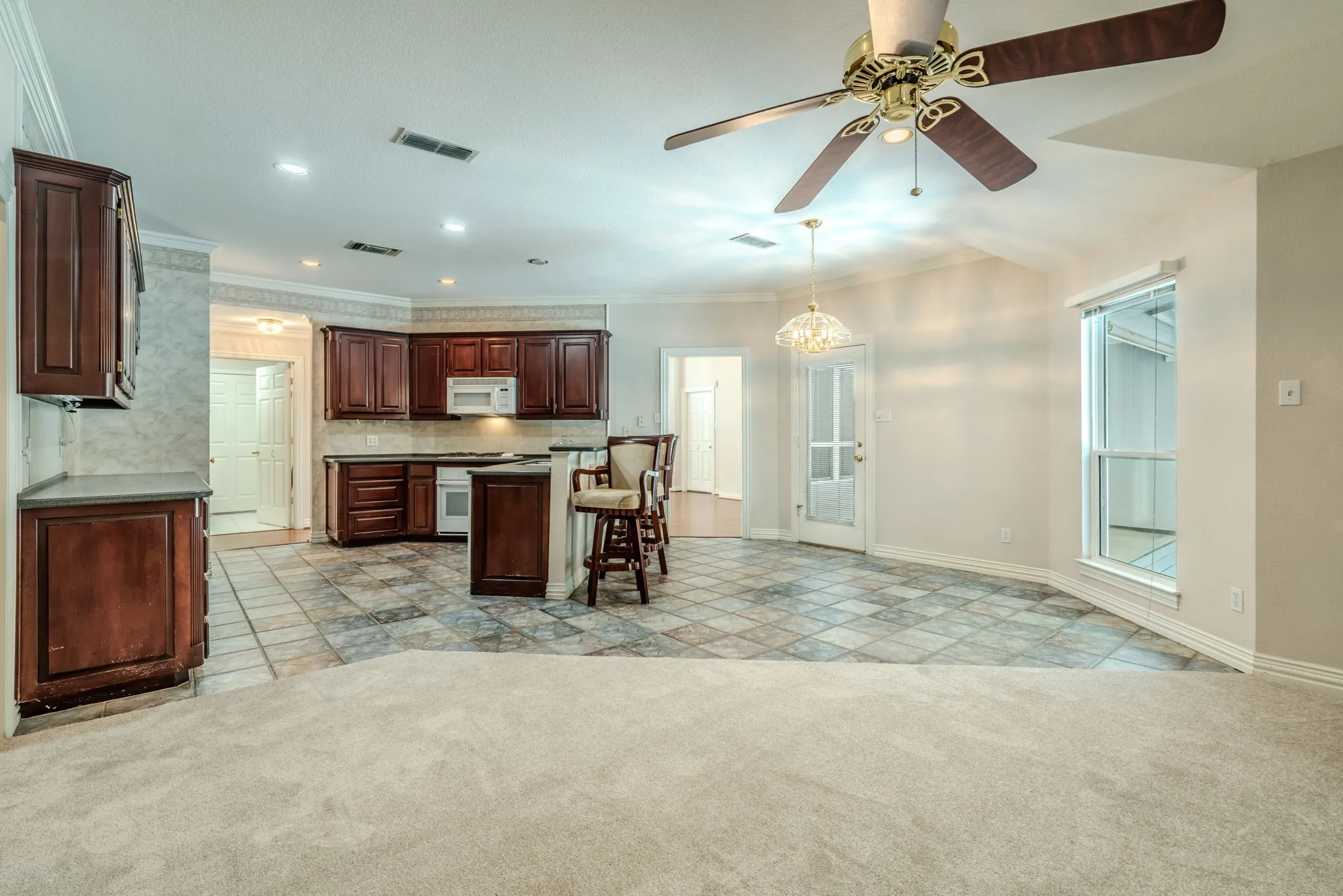 A view of the kitchen and breakfast room from the family room. Notice the doorway that leads to the back patio and deck.