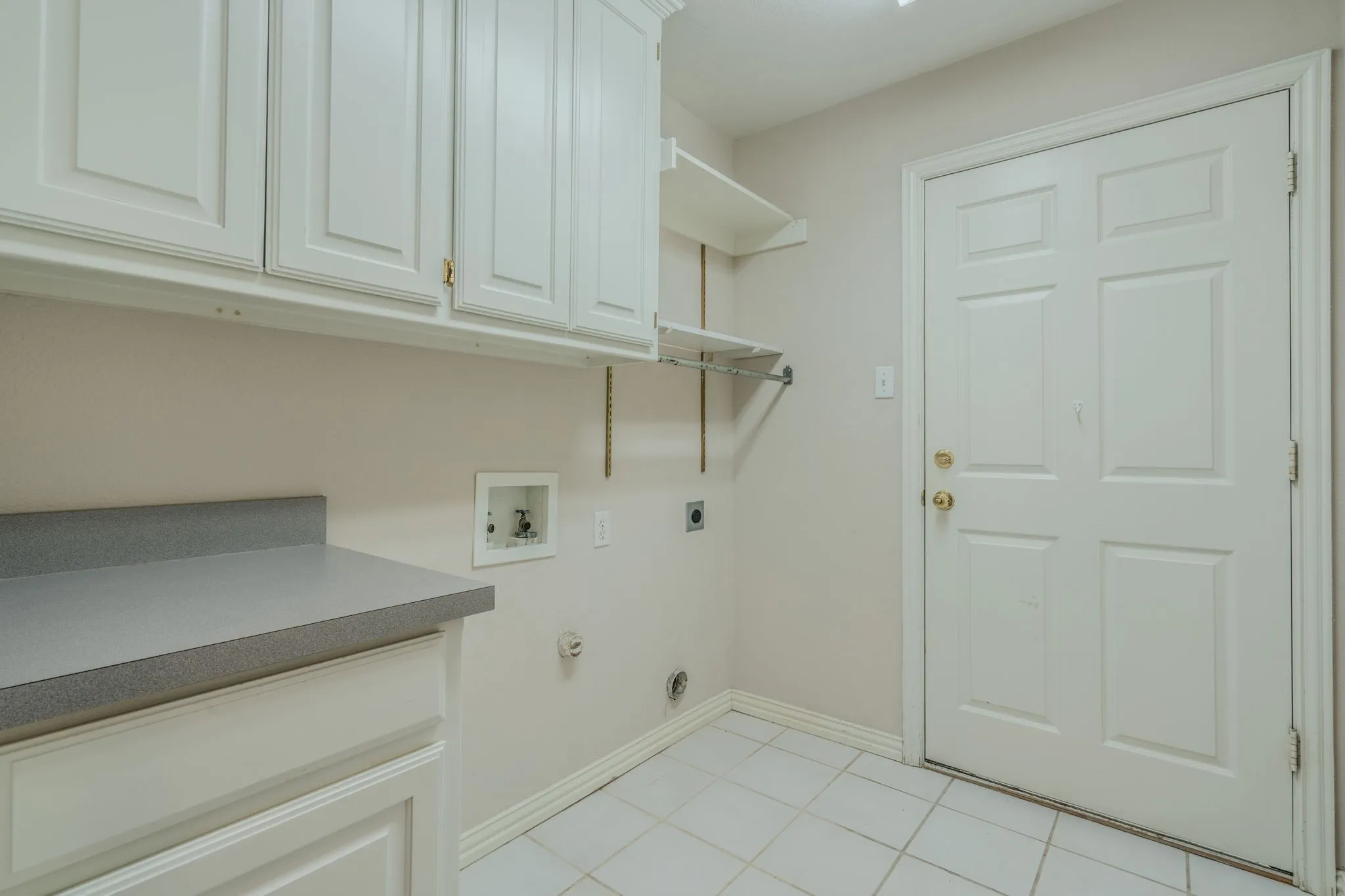 Utility room, which includes cabinets & is located between house & garage