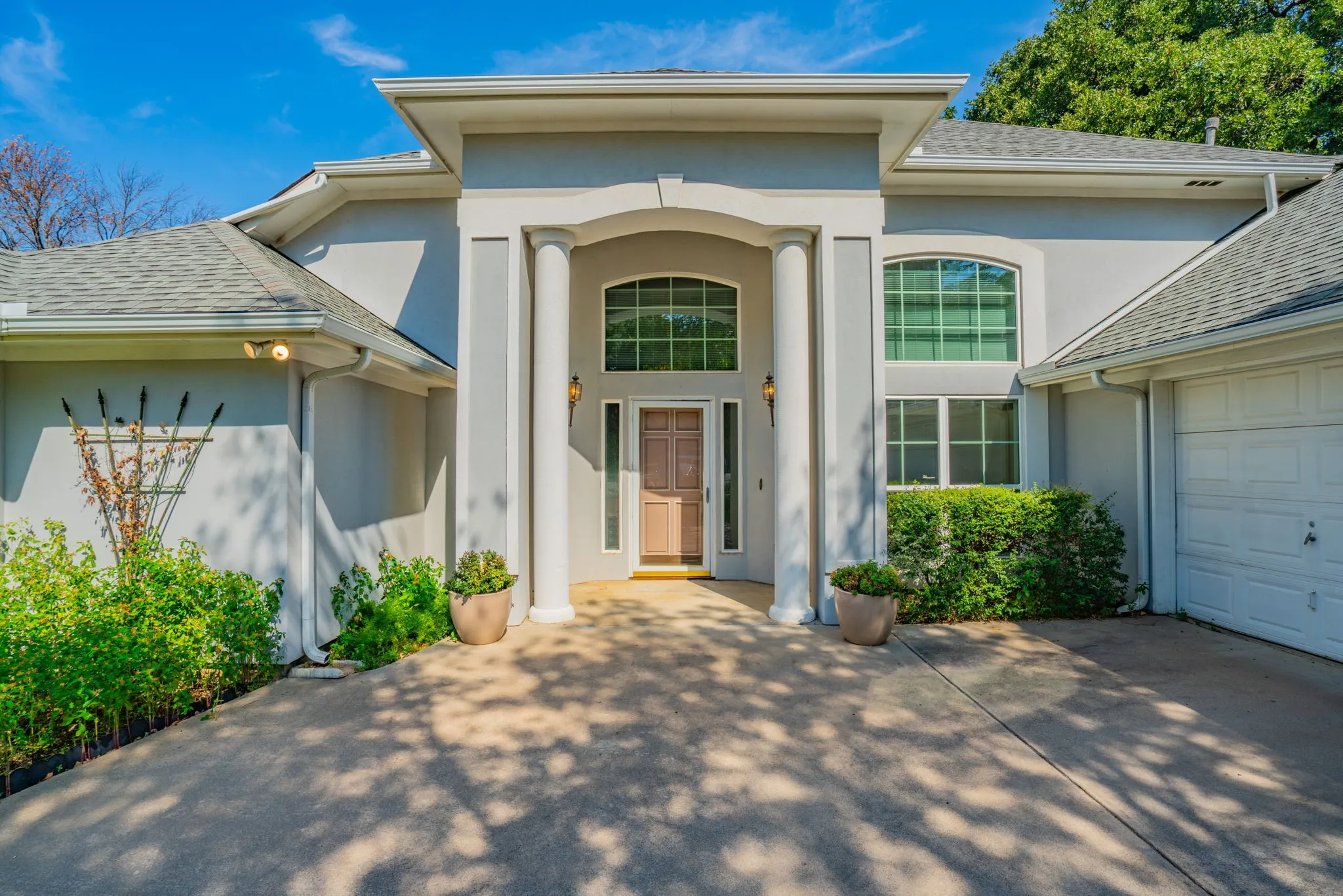 Beautiful front entry to this home! The over-sized swing side entry garage has a built-in work bench and cabinets, to the right of this photo.