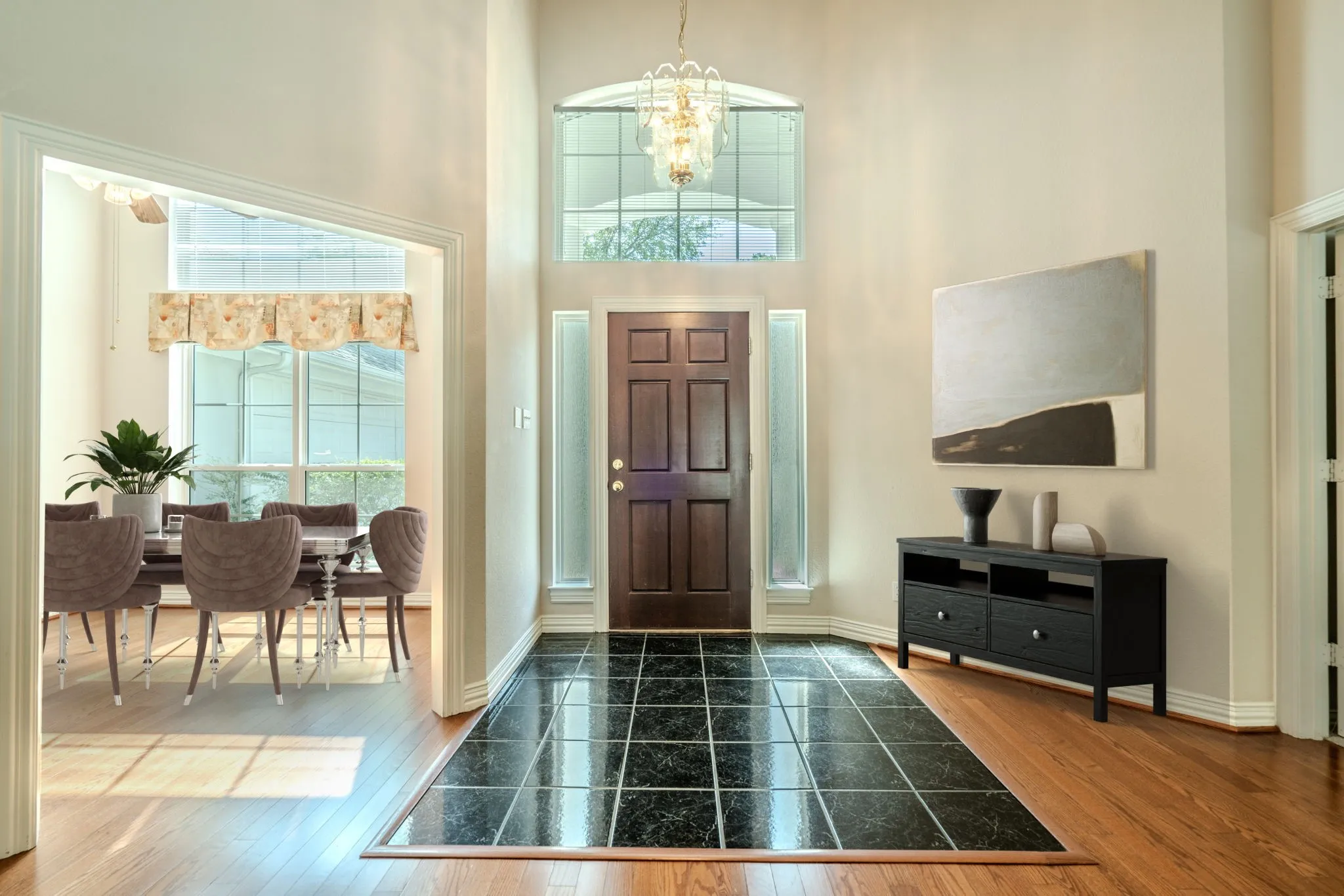 Abundant natural light and 15'-high ceilings enhance the graceful entry, with formal dining on the left of this photo. Virtually staged