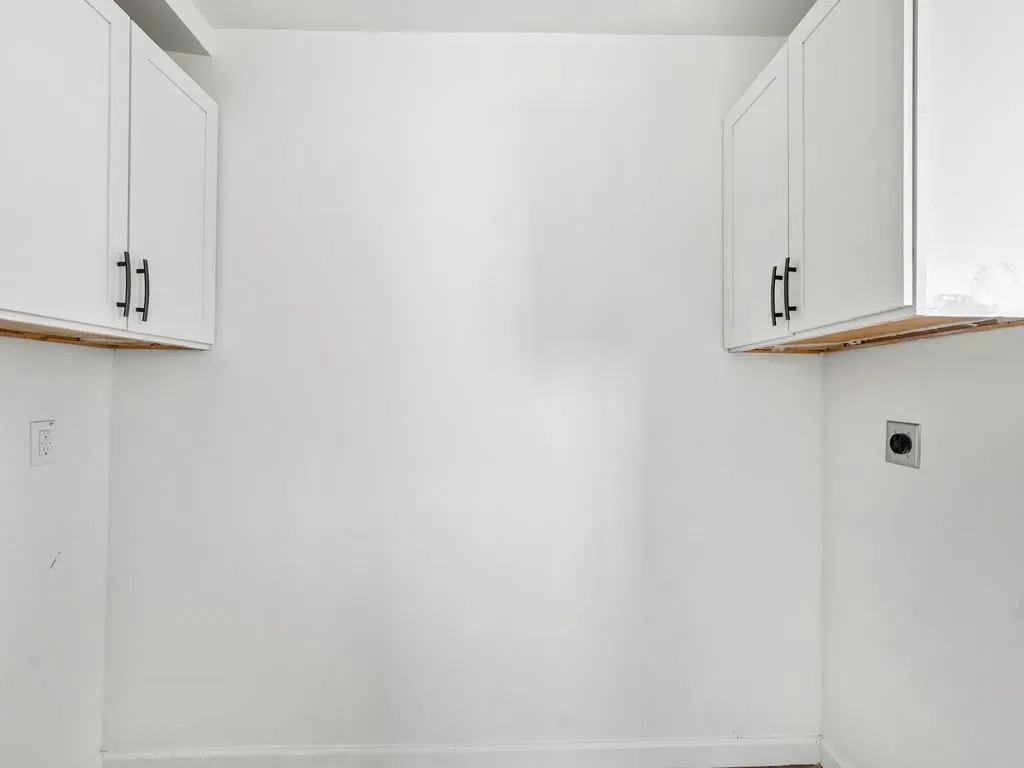 White upper cabinetry with matte black hardware