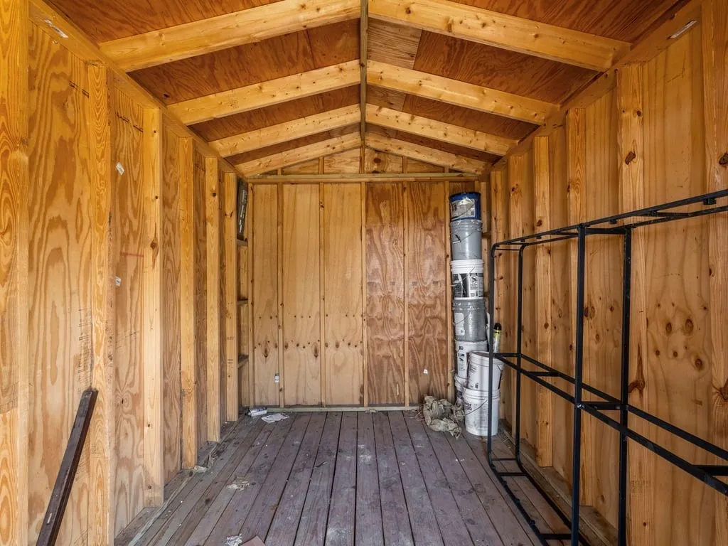 Wood-finish interior walls, exposed ceiling rafters, and wood-plank flooring