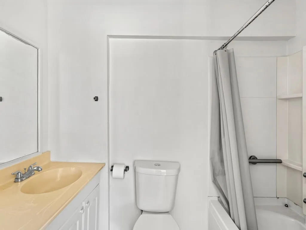 White vanity with a neutral-toned countertop and an undermount sink