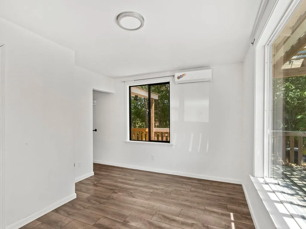 Wood-finish flooring, white walls, and a contemporary ceiling light fixture