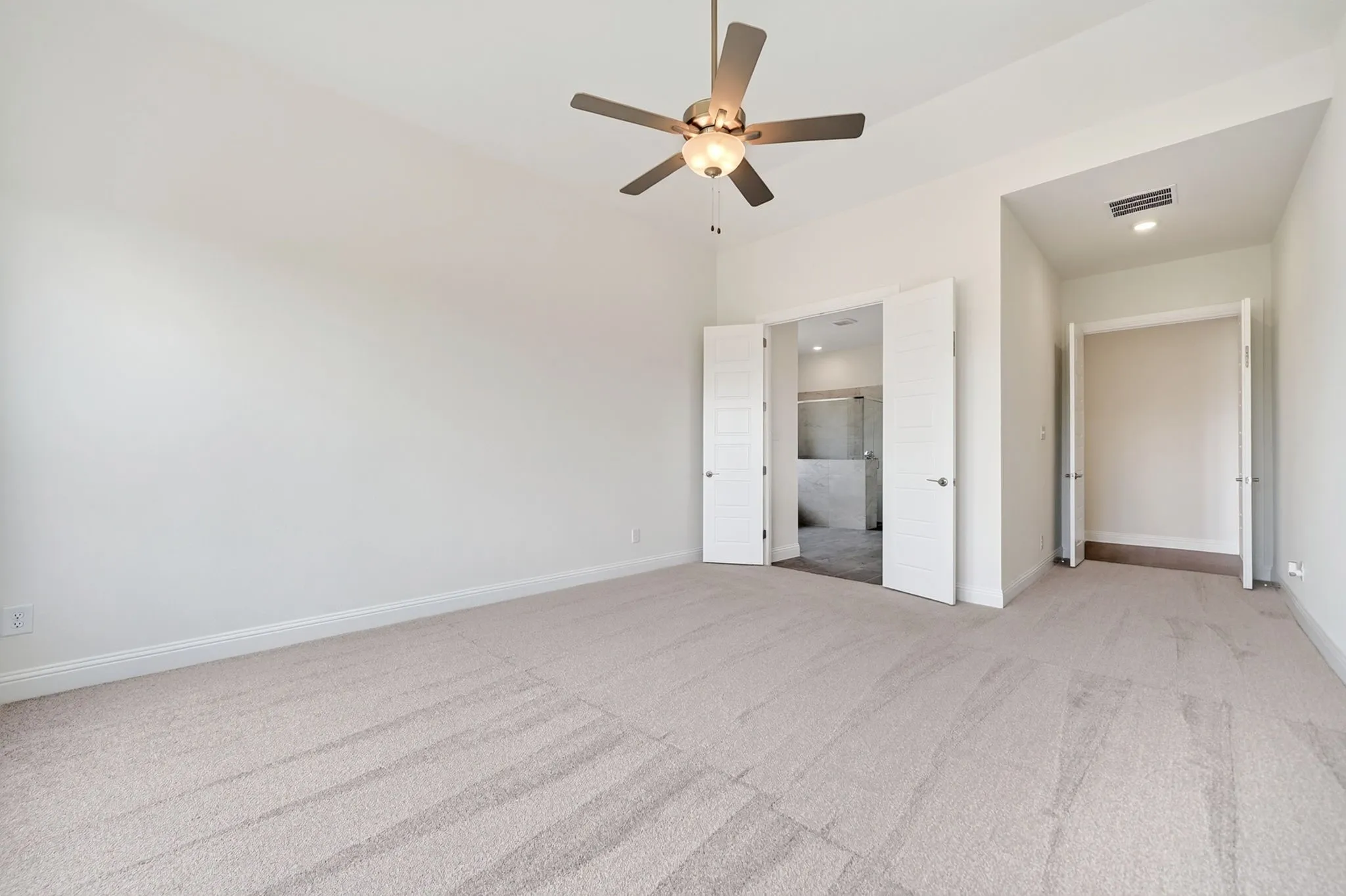Carpeted flooring, ceiling fan with integrated lighting, double French doors, recessed lighting, and a walk-in closet