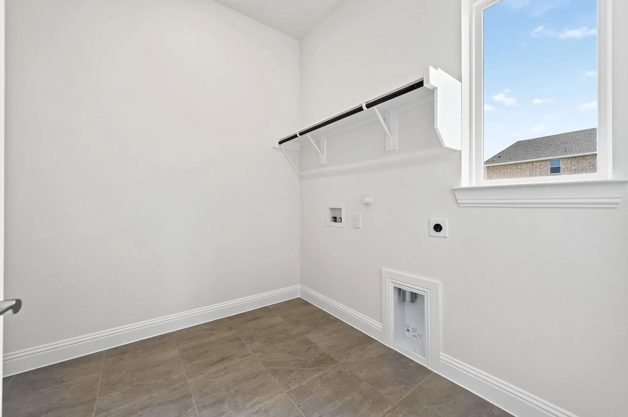 White walls, tiled flooring, built-in shelving, and a single window
