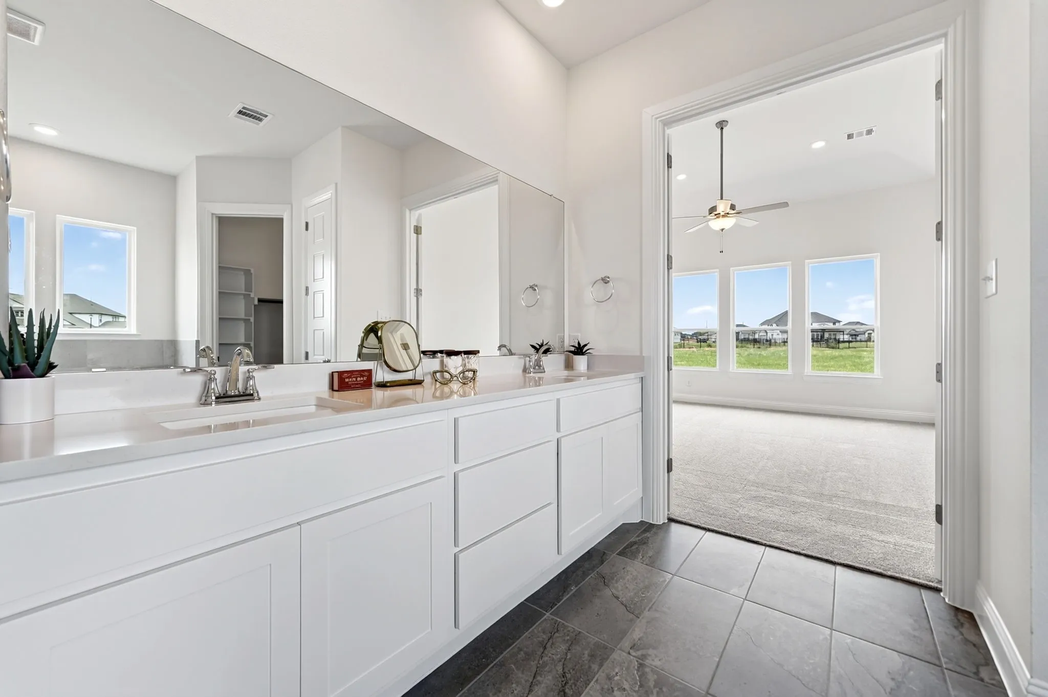 Dual vanity with white cabinetry, light-toned countertop, and undermount sinks