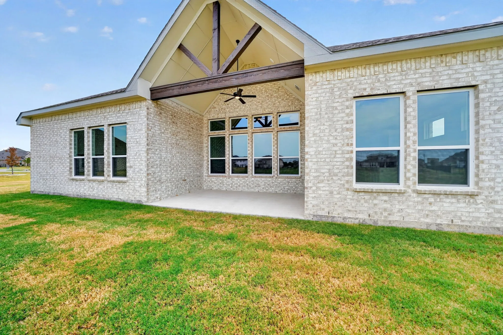 Expansive rear patio with vaulted ceiling and exposed wood beams