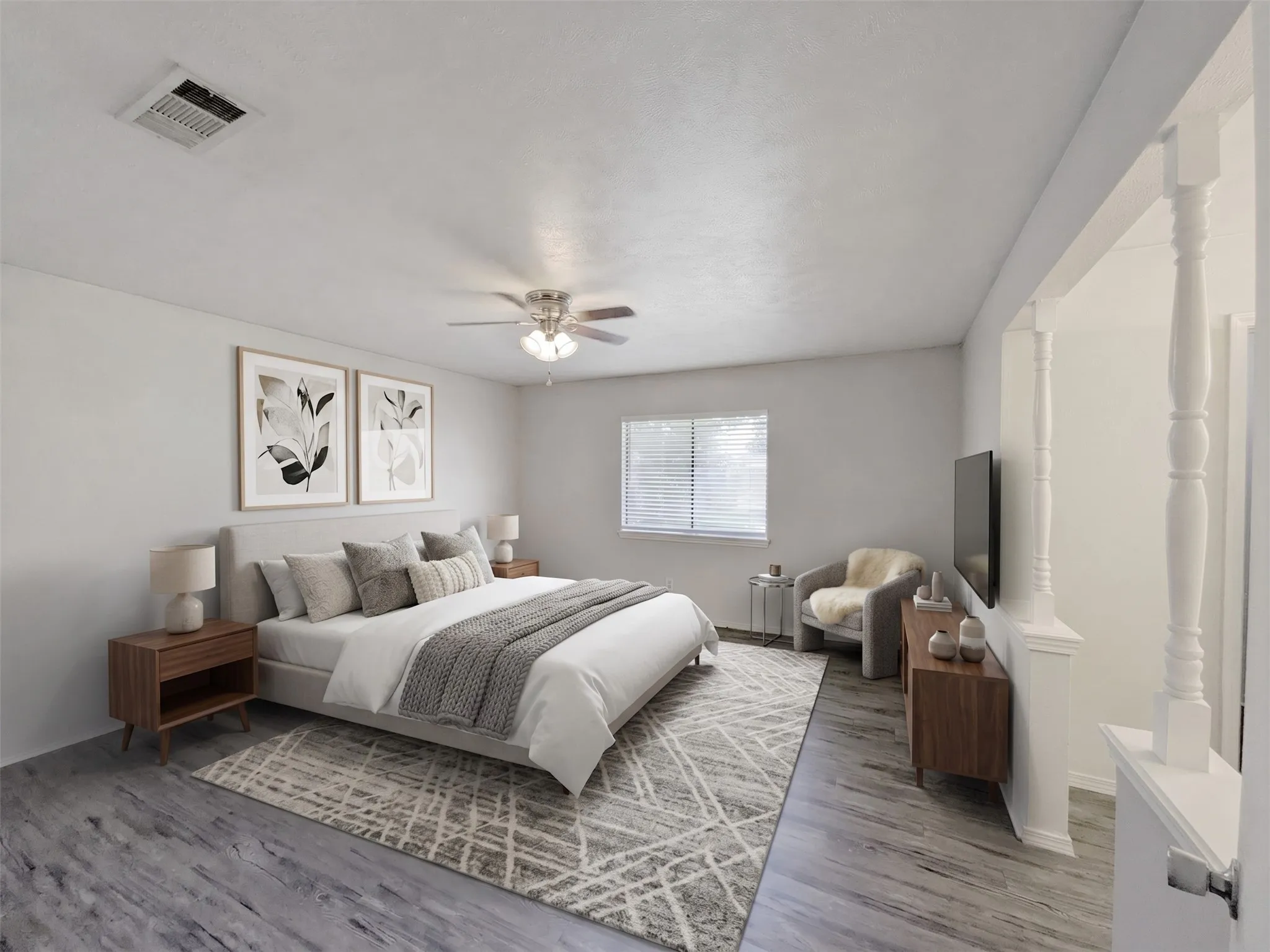Wood-finish flooring, ceiling fan with integrated lighting, window with horizontal blinds, half-wall with decorative balusters