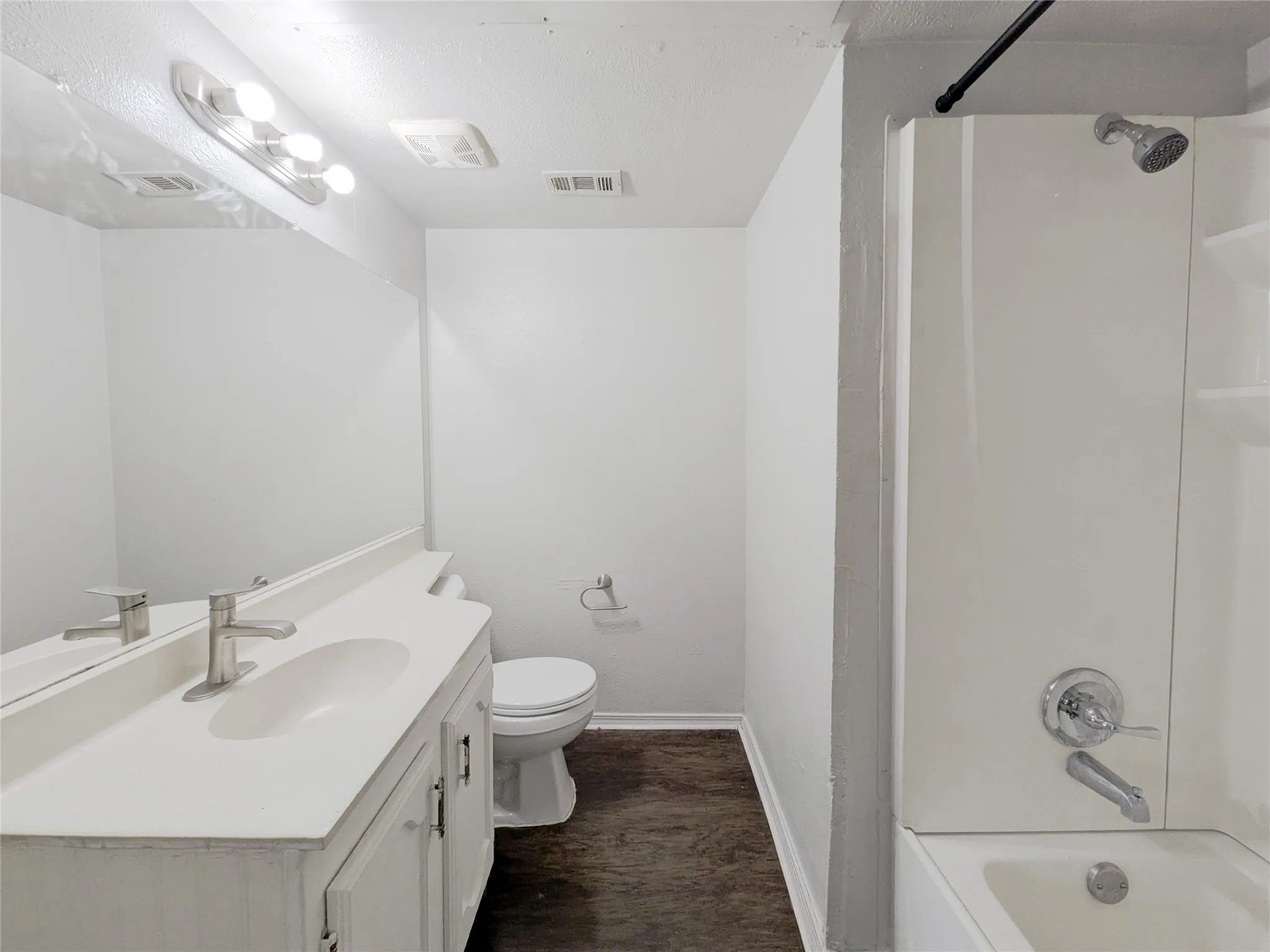 Vanity with dual sinks, brushed nickel fixtures, and extensive mirror