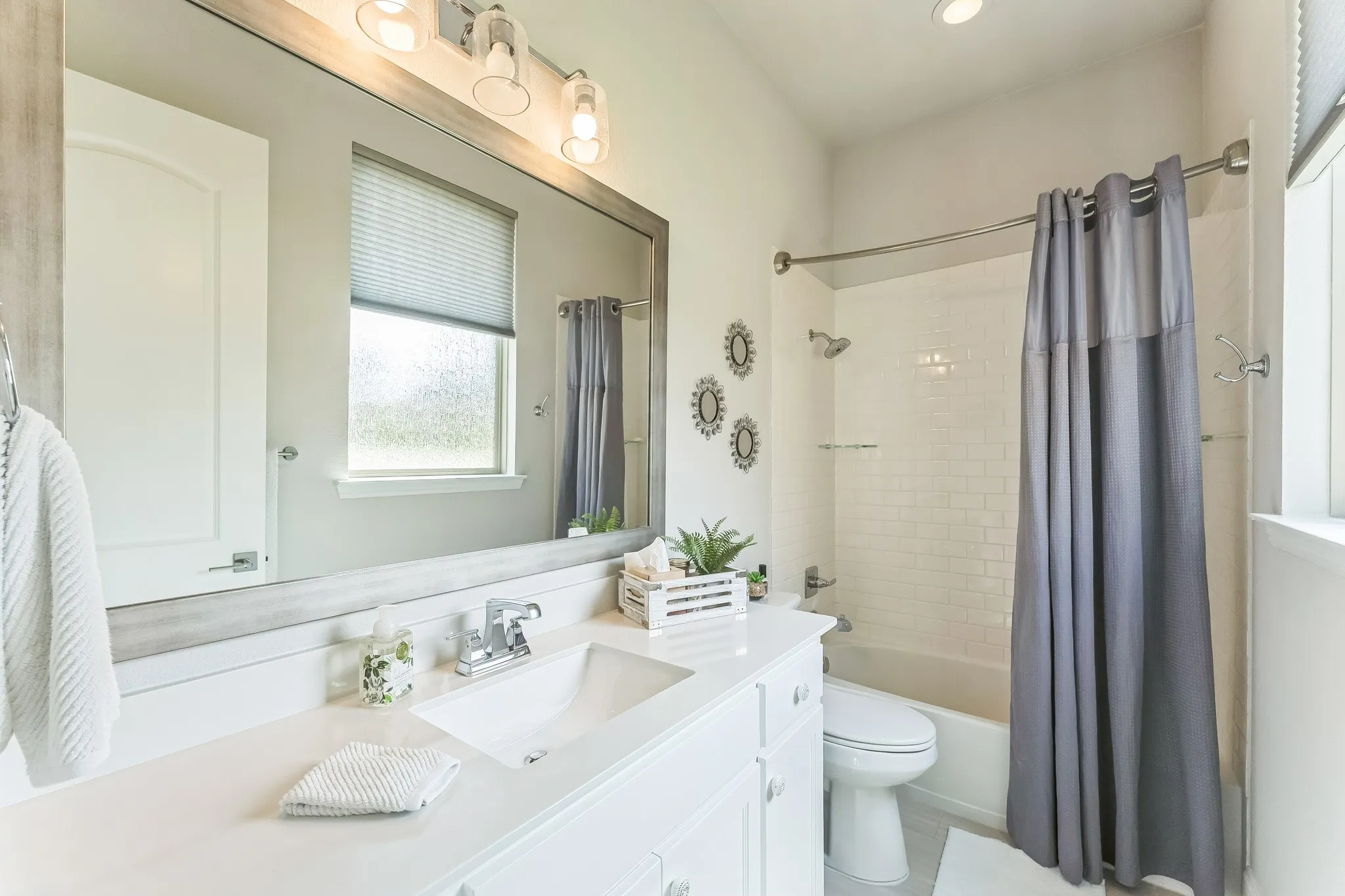 White vanity with a rectangular undermount sink and chrome faucet