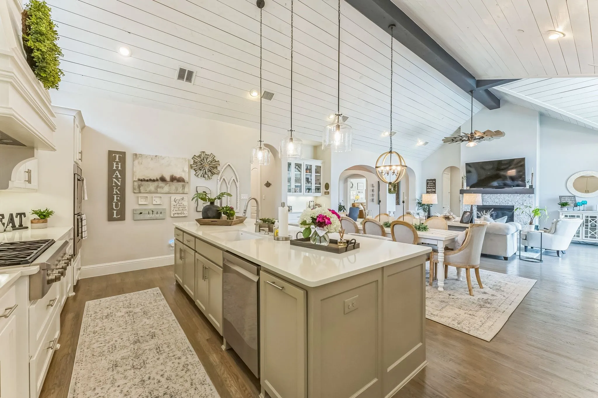 Kitchen featuring a large central island with a sink, stainless steel appliances, and white shaker-style cabinetry