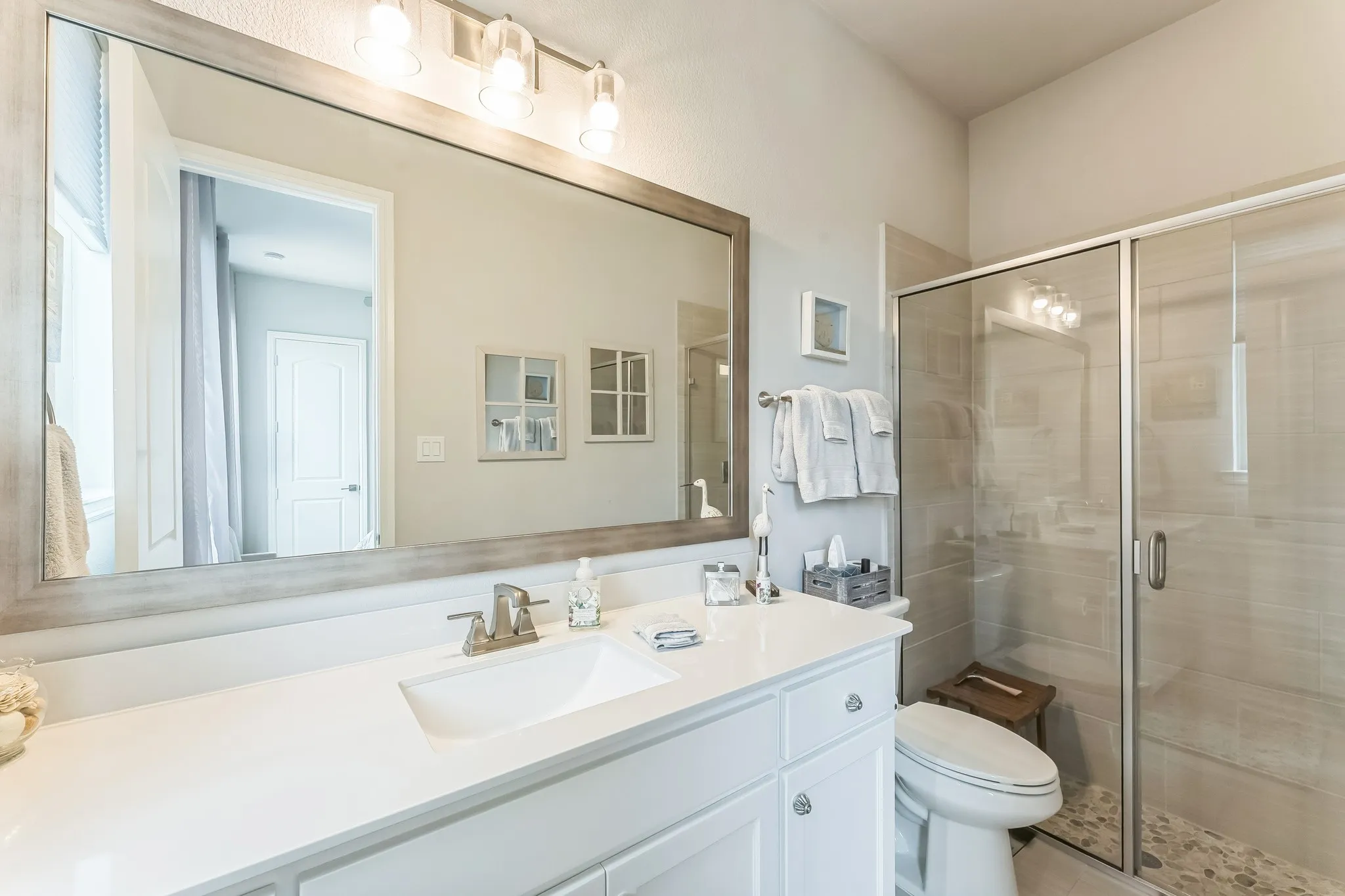 White vanity with a single basin sink and brushed nickel faucet