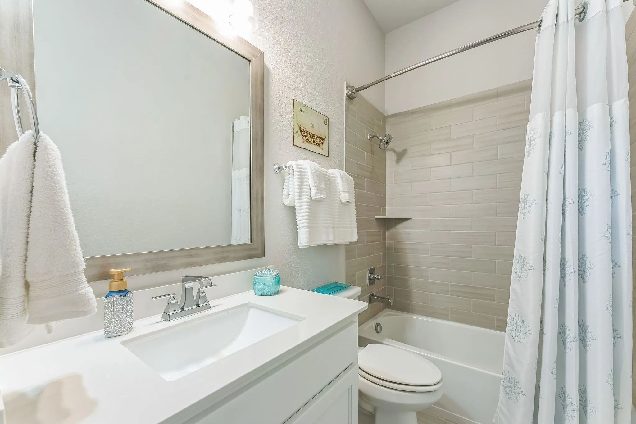Vanity with integrated sink, rectangular framed mirror, and chrome faucet