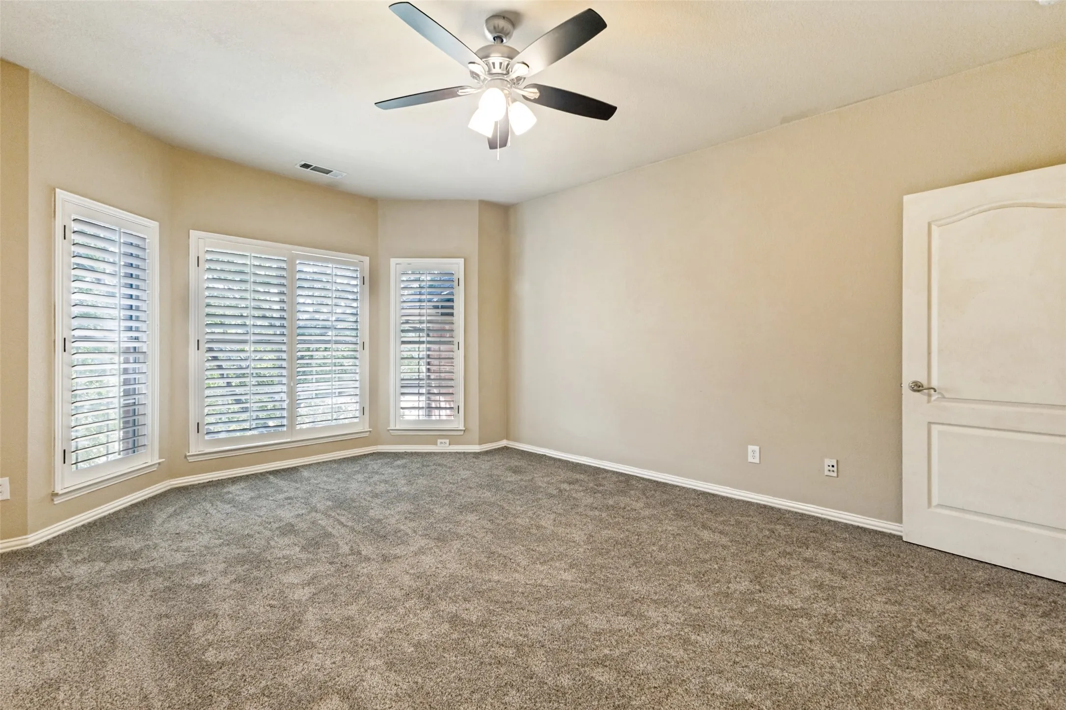 Large upstairs bedroom with plantation shutters.