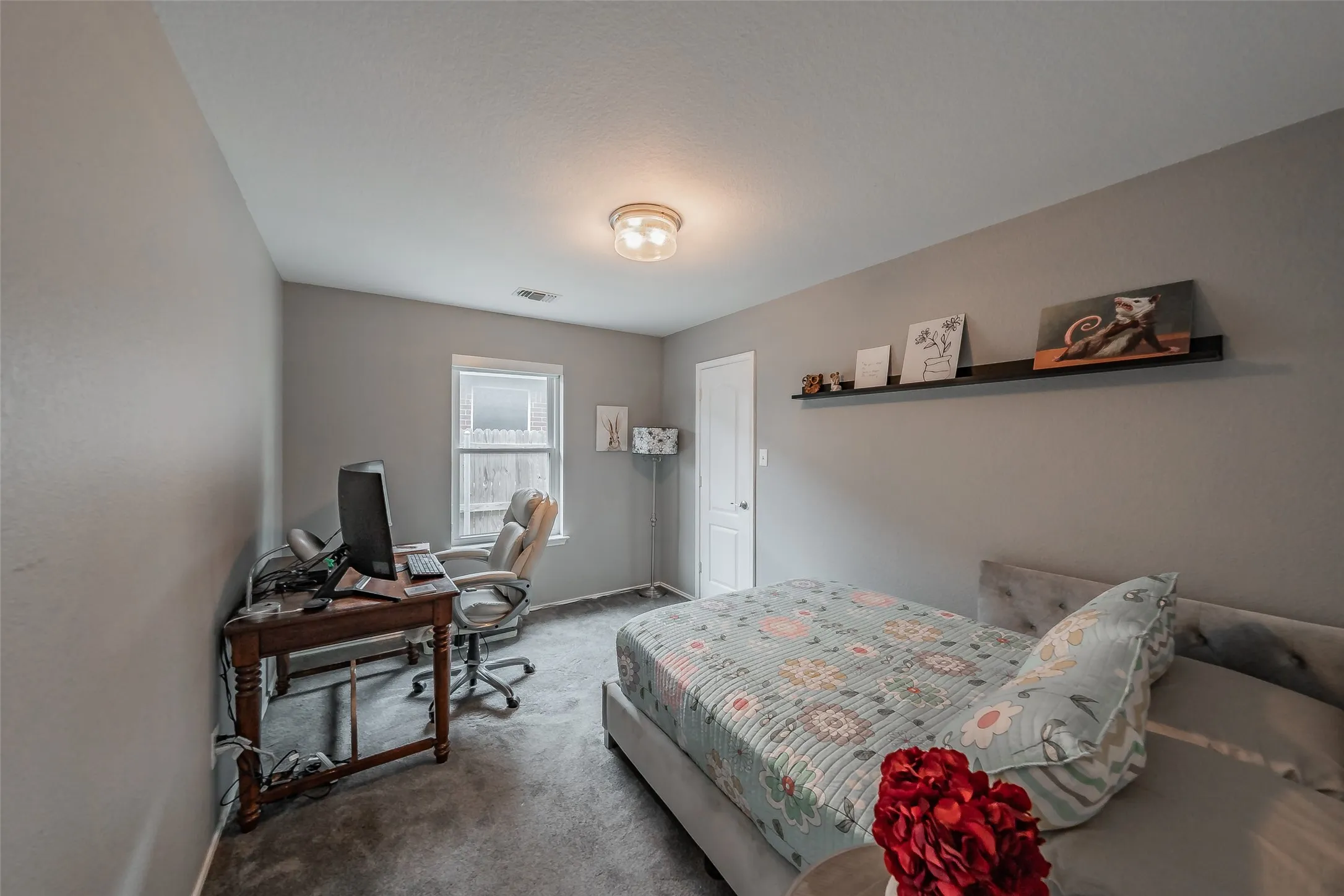 Wall-to-wall carpeting, window with privacy glass, single-panel interior door, and a flush mount ceiling light fixture